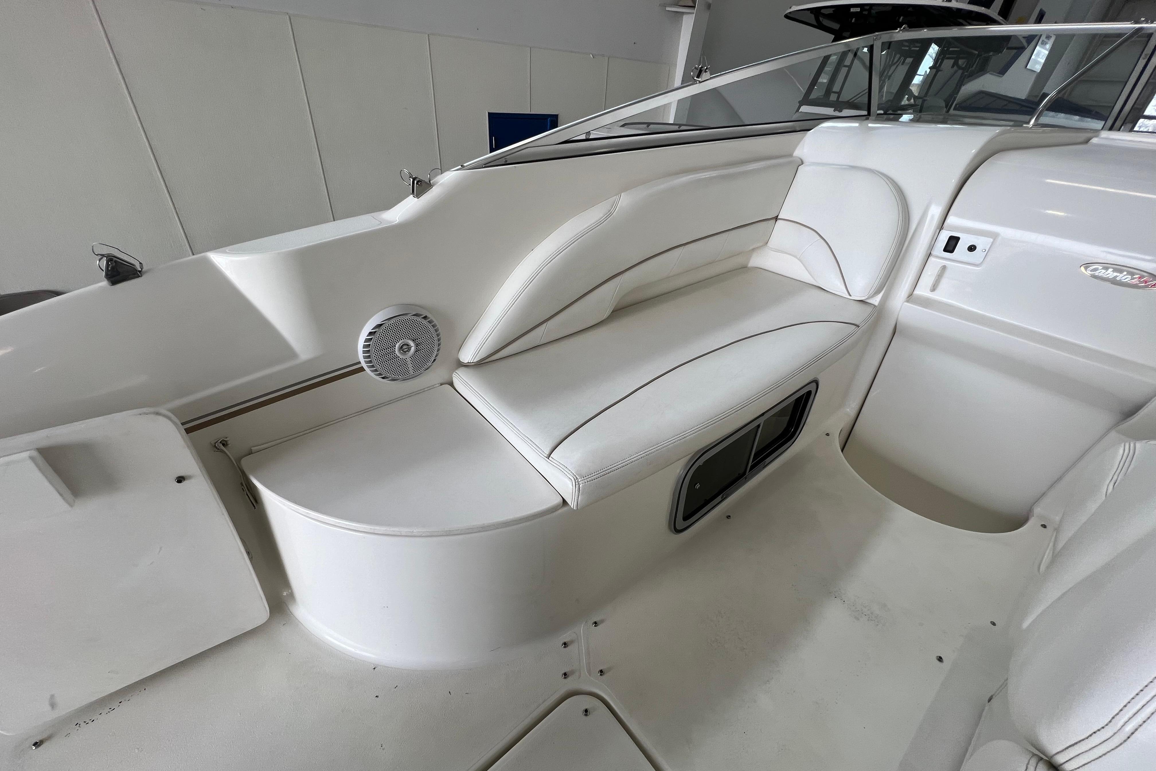 2002 Larson Cabrio 254 boat interior with white seating and speaker.