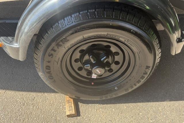 Trailer wheel of 2026 Tracker Super Guide V-16 SC on pavement.