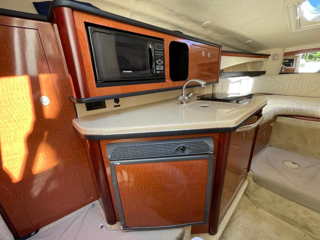 Interior of the 2005 Sea Ray Sundancer 260 with a kitchenette and seating area.
