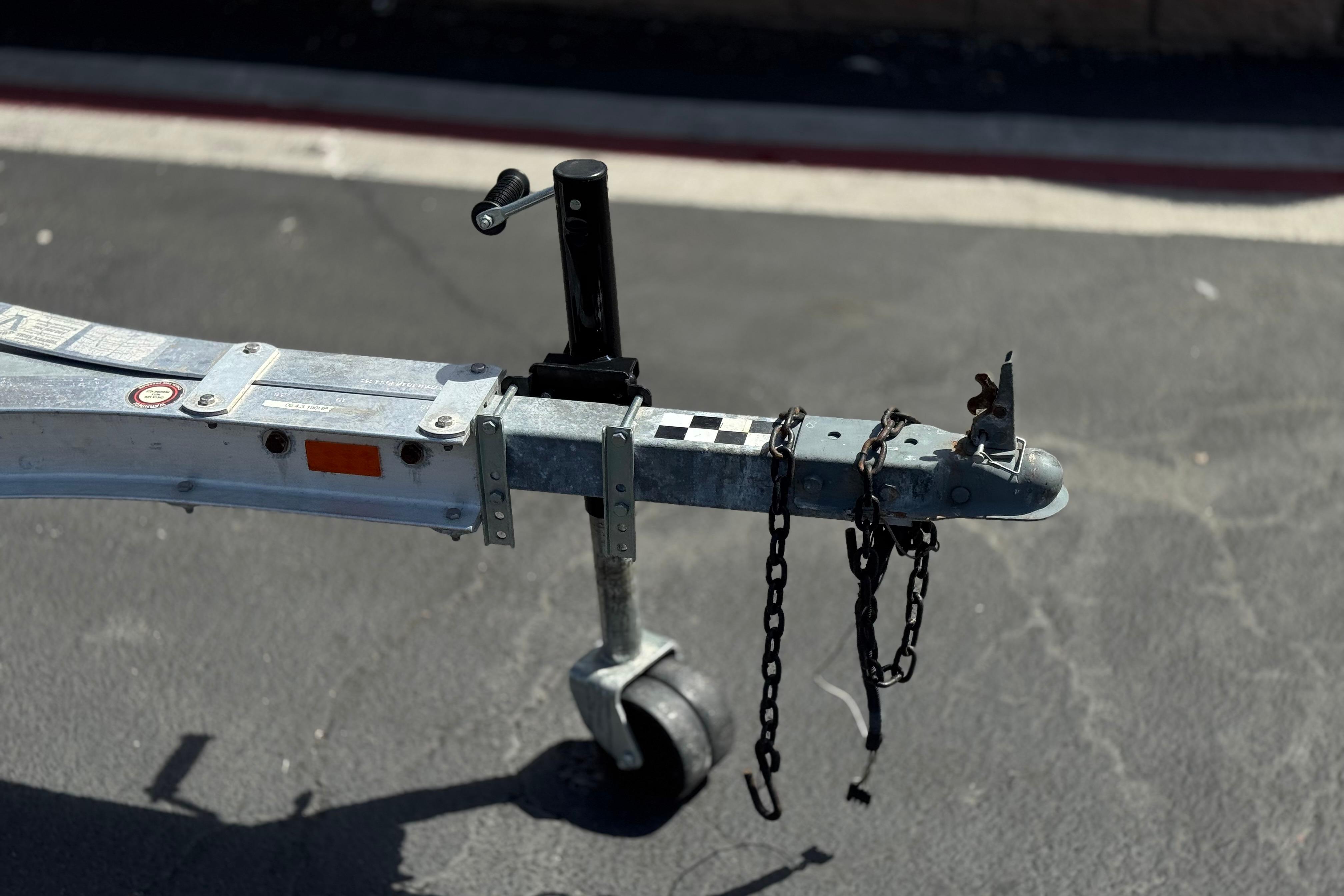 Trailer hitch of a 2006 Chaparral 190 SSi boat on pavement.