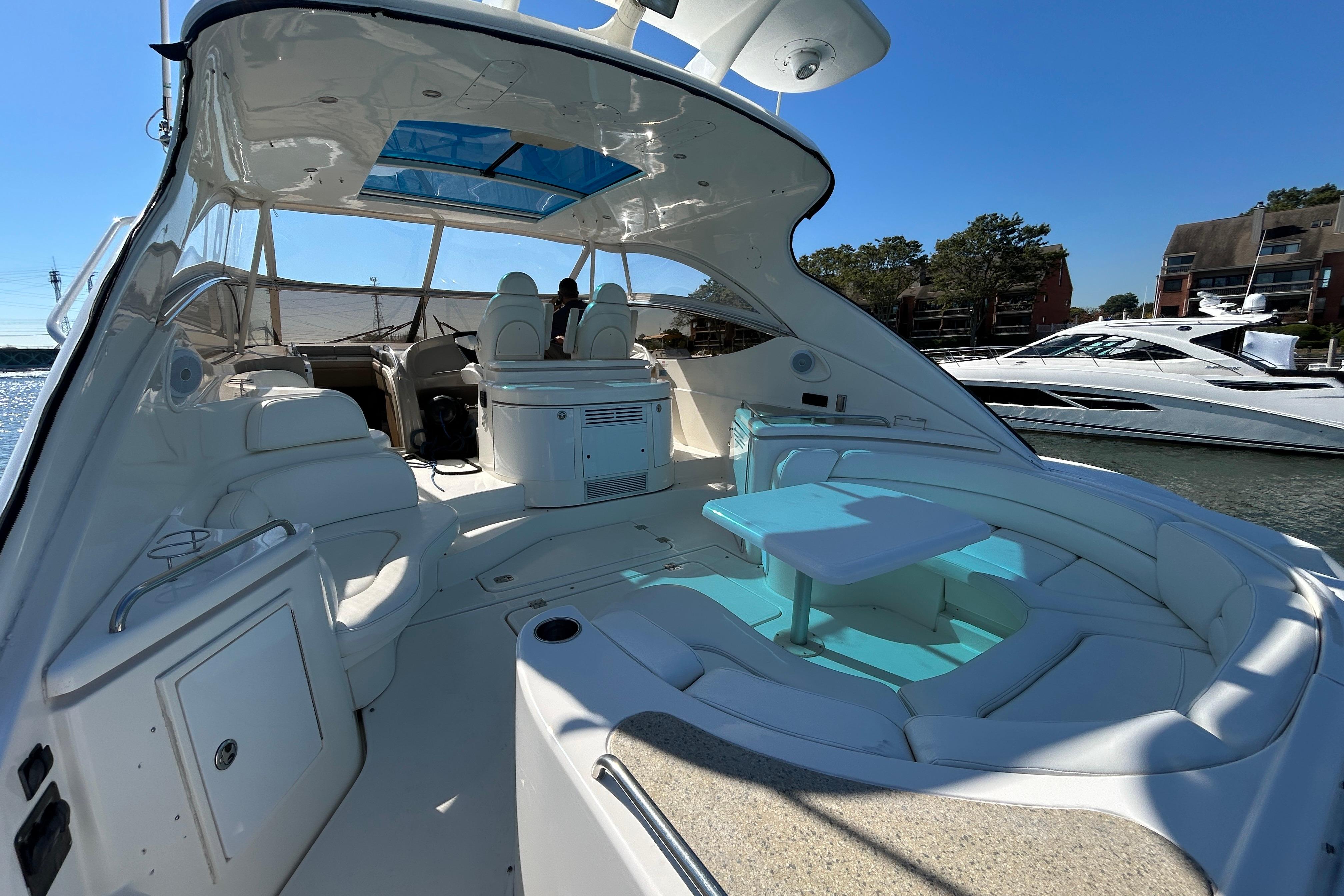 2003 Cruisers Yachts 540 Express interior with seating and table, docked in a marina.