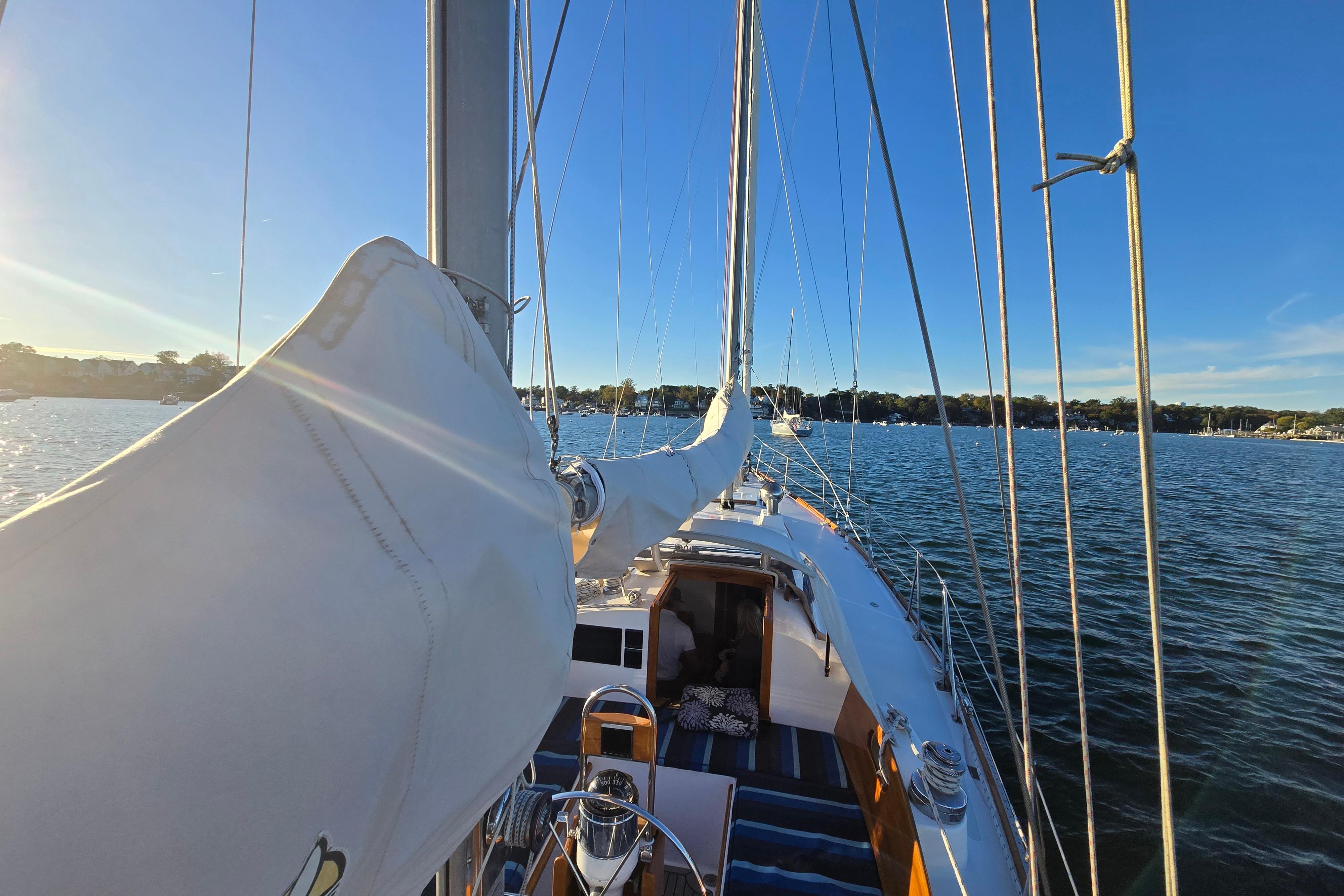 1970 Hinckley Bermuda 40 sailboat on calm water under clear blue sky.
