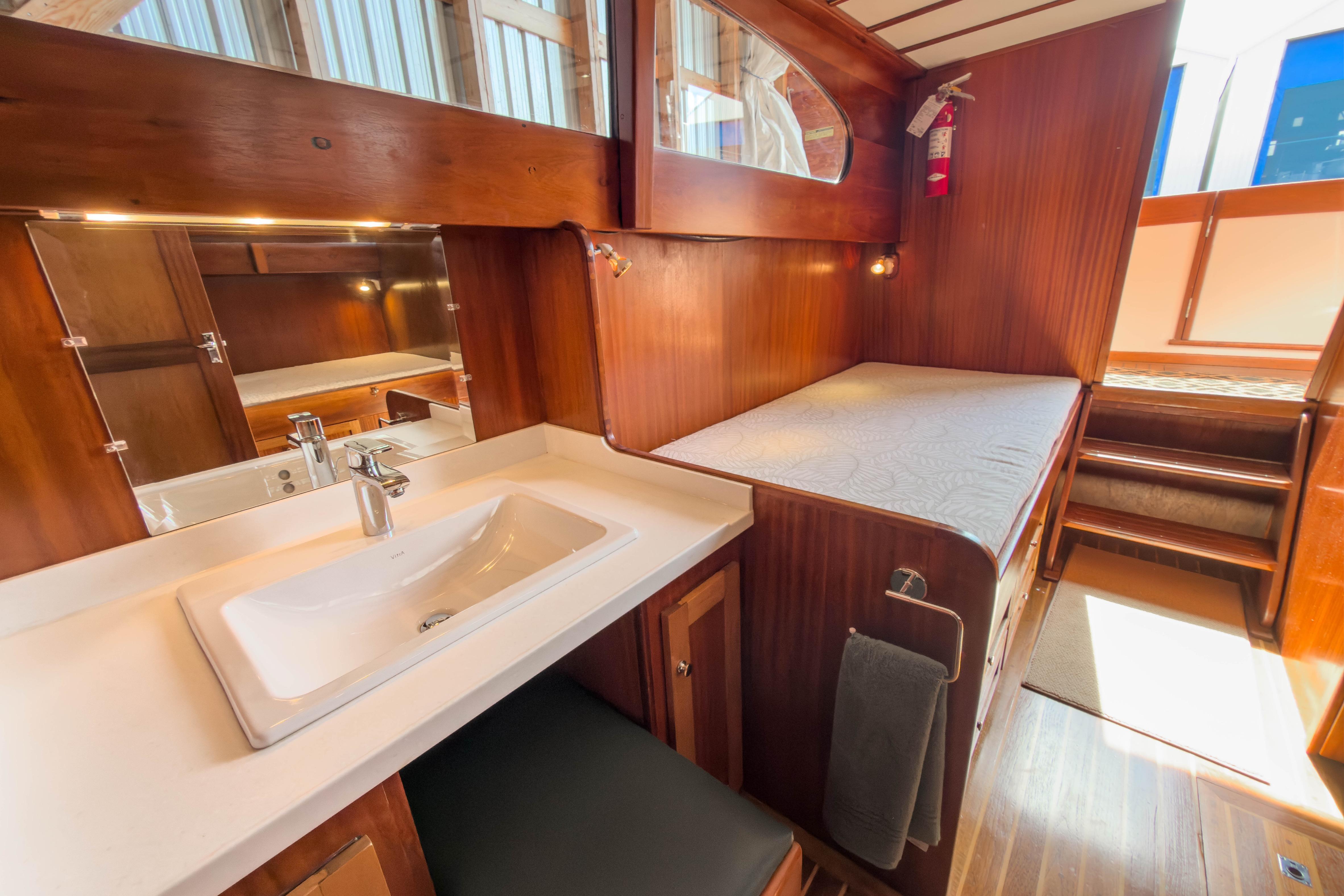 1957 Monk Tri-Cabin interior with wooden finish, sink, and cozy sleeping area.