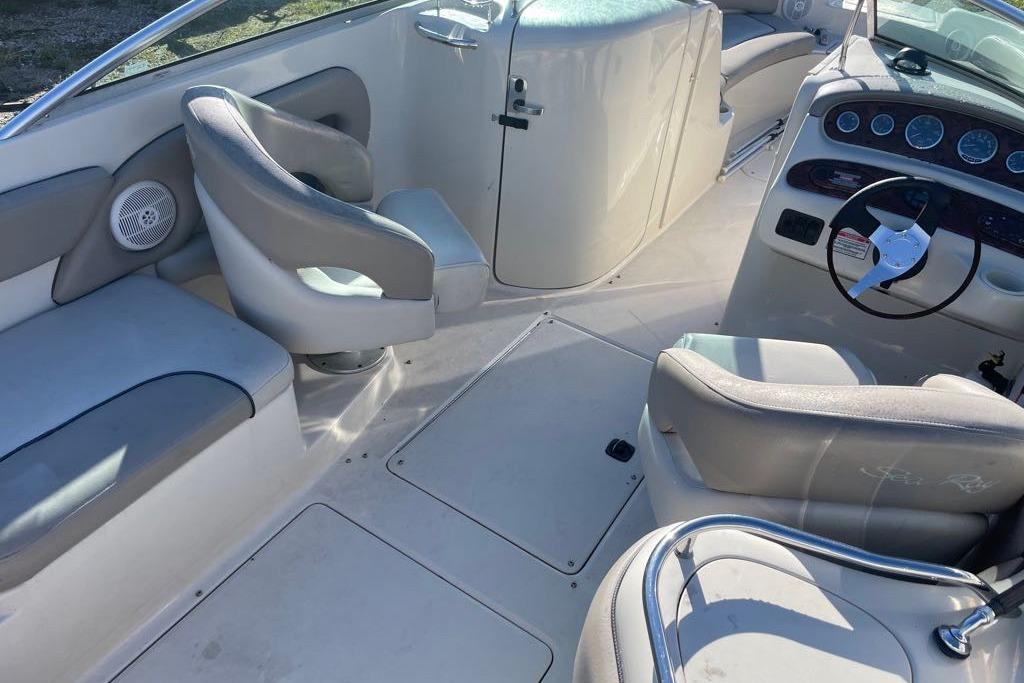 2004 Sea Ray 240 Sundeck interior with seating and steering wheel, showcasing spacious design.