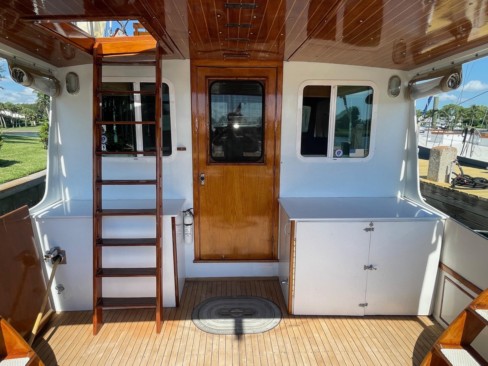 1979 Jarvis Newman Trawler with wooden ladder and door, white cabinets, and teak deck.