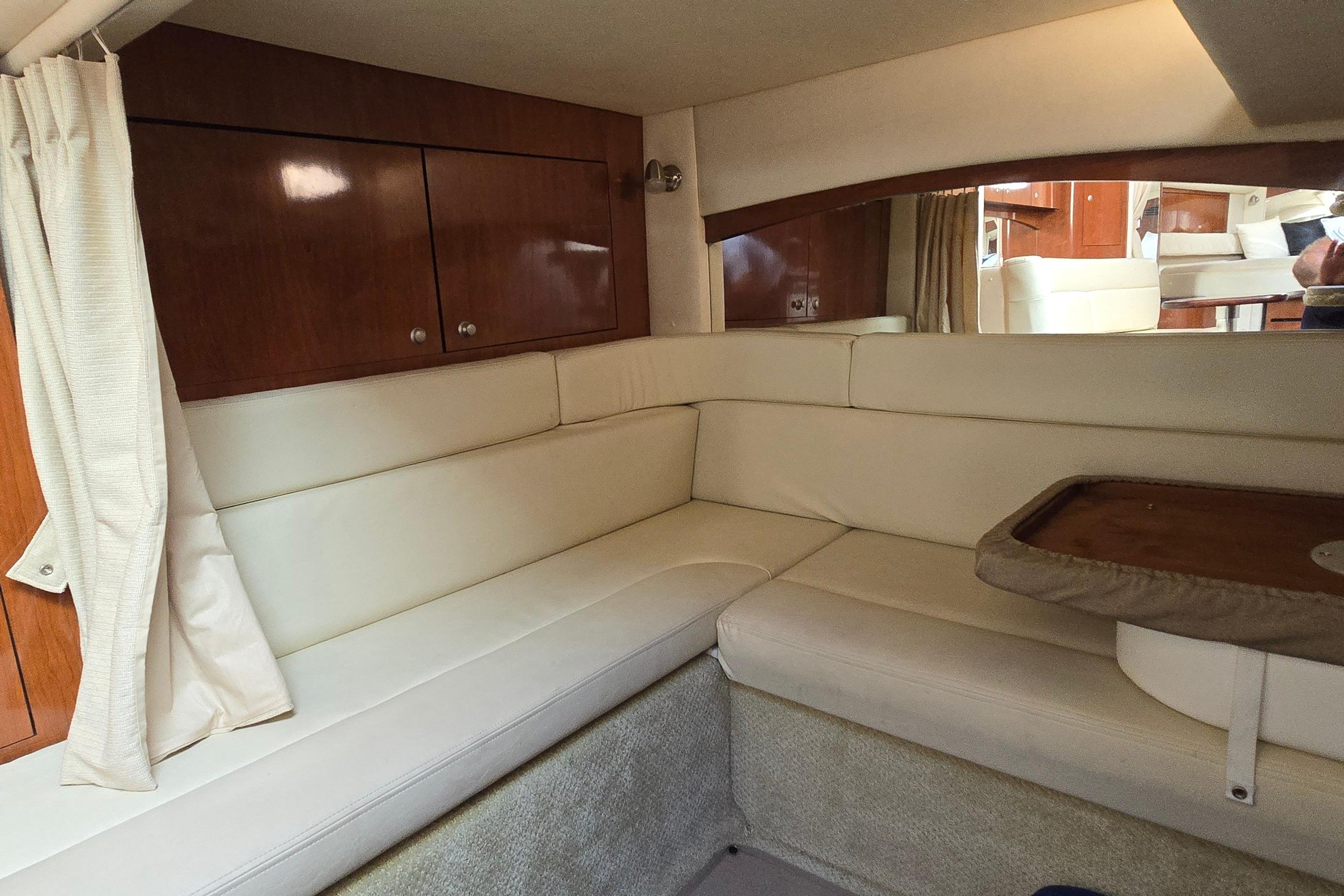 Interior of 2007 Sea Ray 340 Sundancer with cream leather seating and wooden cabinetry.