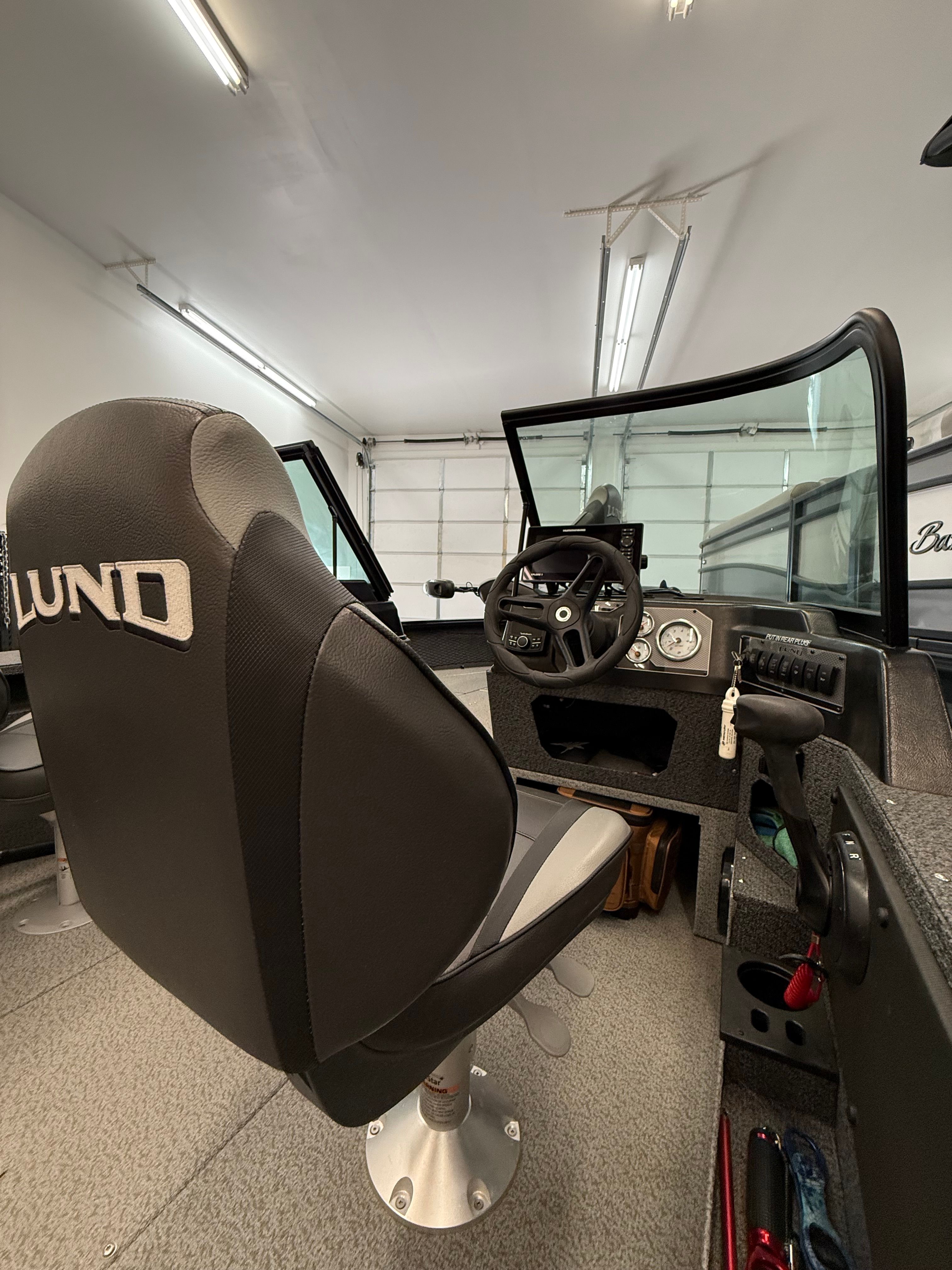 Interior of a Lund 1875 Impact XS Sport with helm and seating.