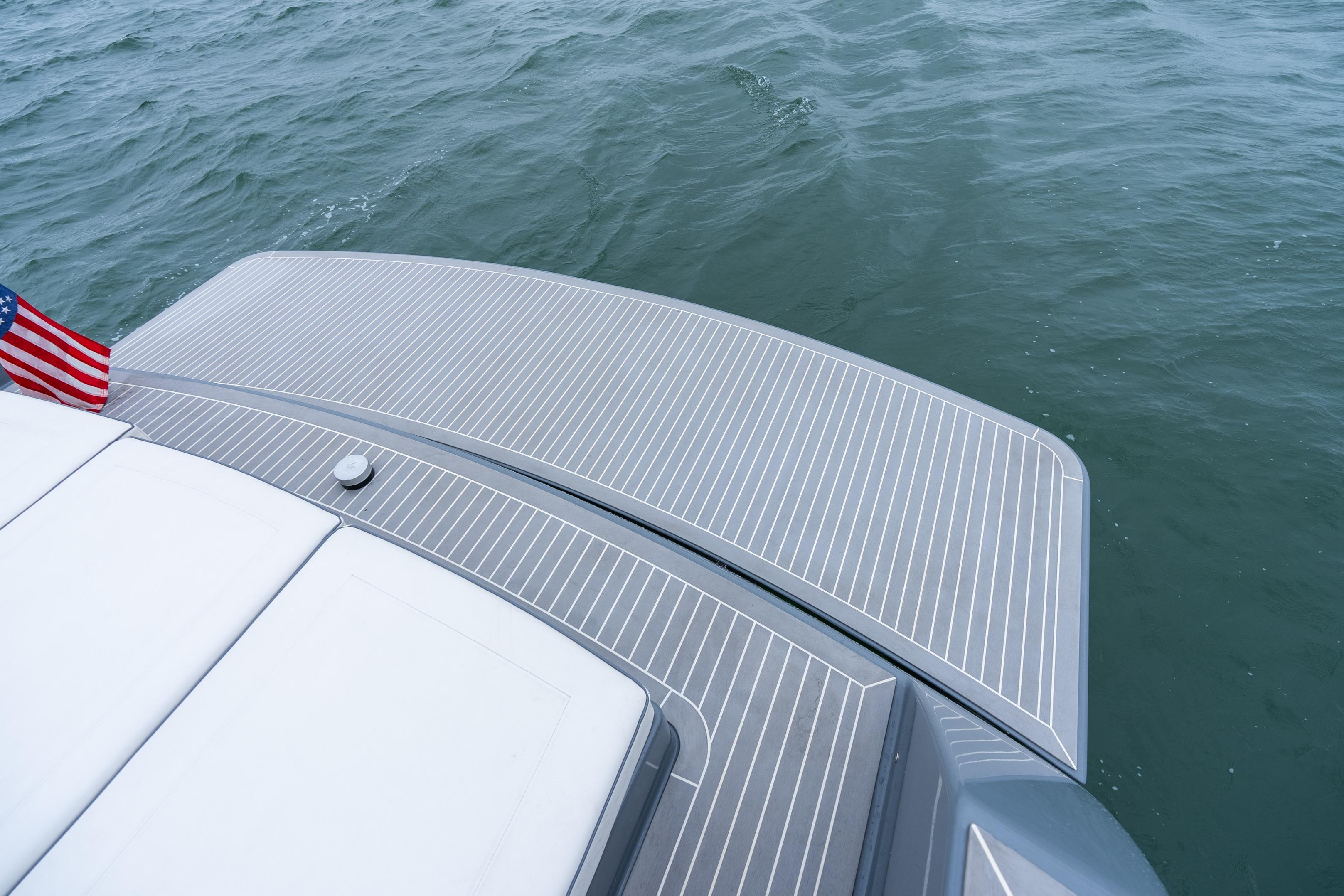 VanDutch 48 yacht deck with American flag, 2023 model, on calm water.