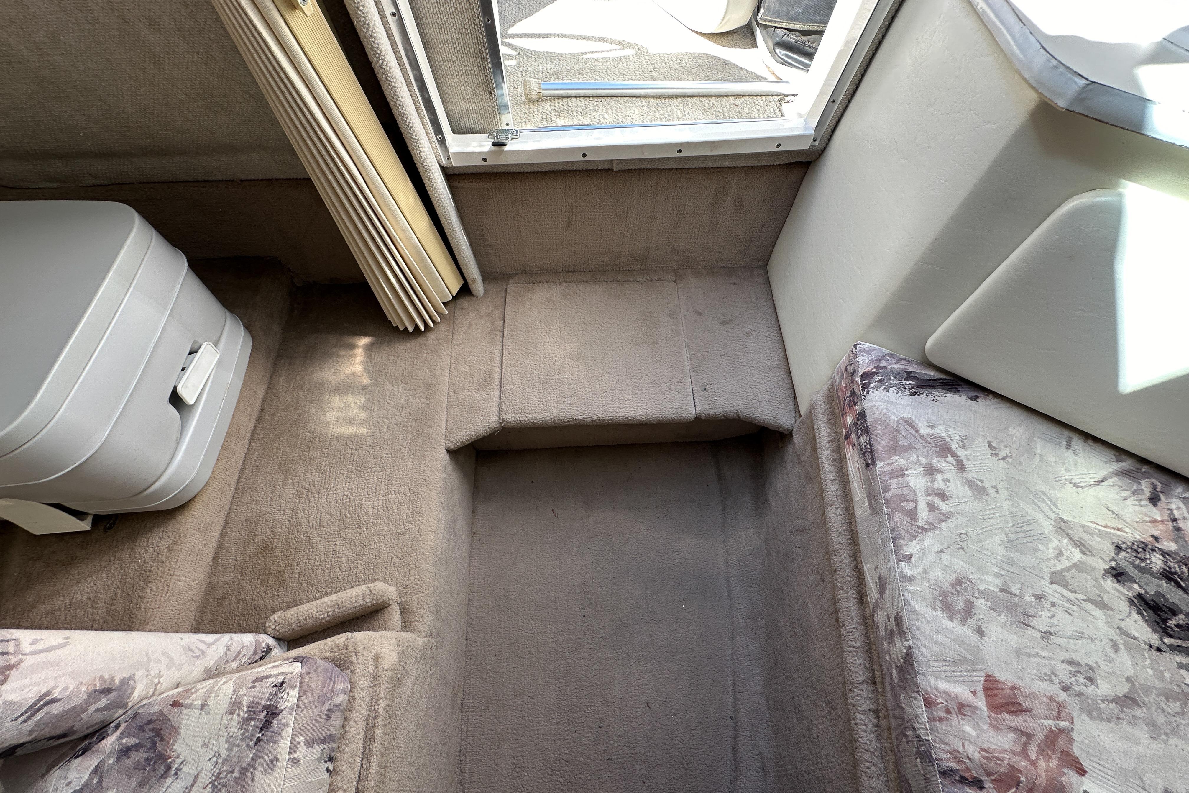 Interior of 1998 Sea Ray 215 Express Cruiser with compact toilet and seating area.