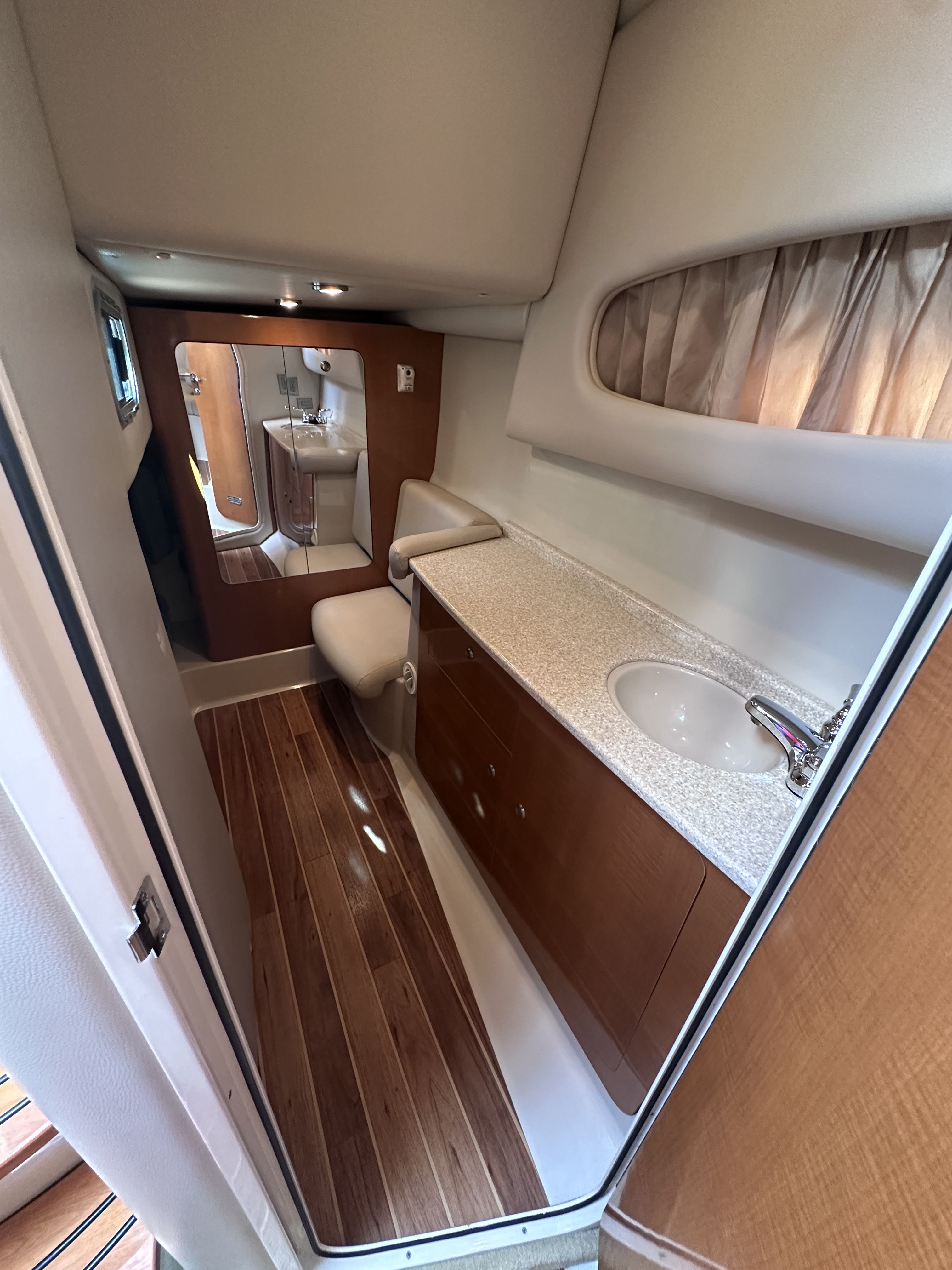 The image shows the bathroom of a 2008 Chaparral Signature 330. It features wood flooring, a sink, and a mirror.
