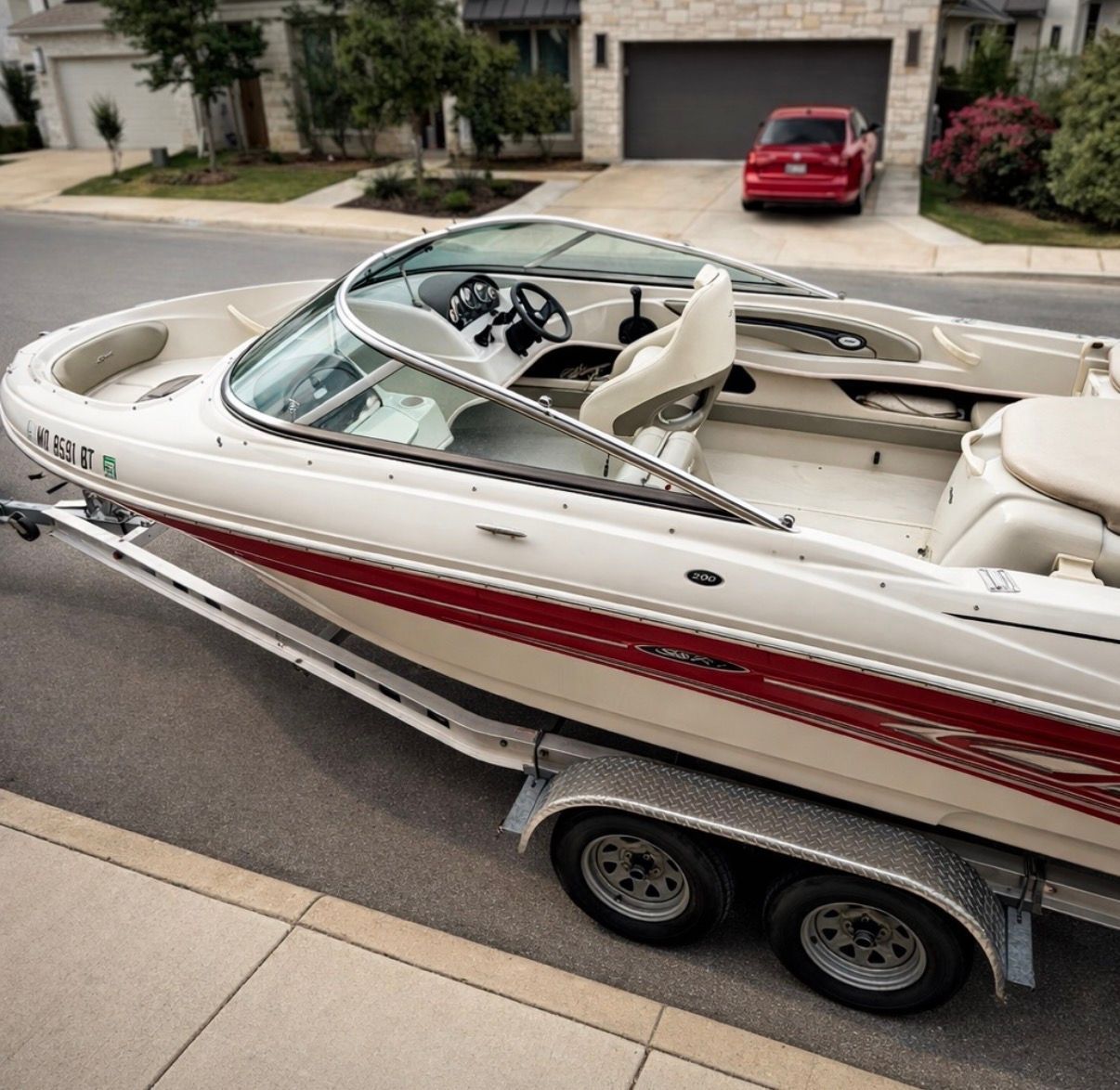 2005 Sea Ray 200 Sport boat on trailer in residential area.