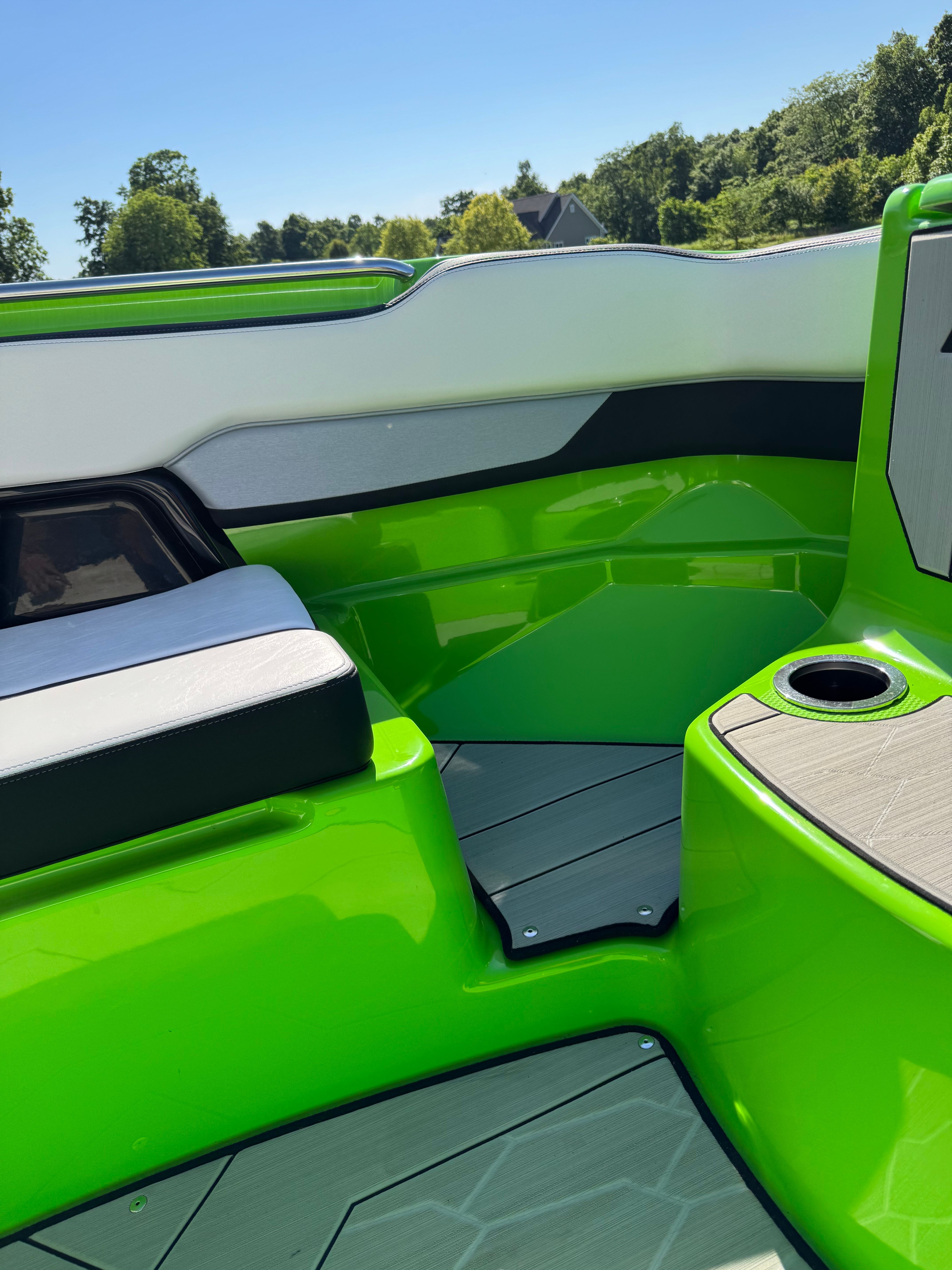 Green interior of a Yamaha 255XD boat with seating area and cup holder.