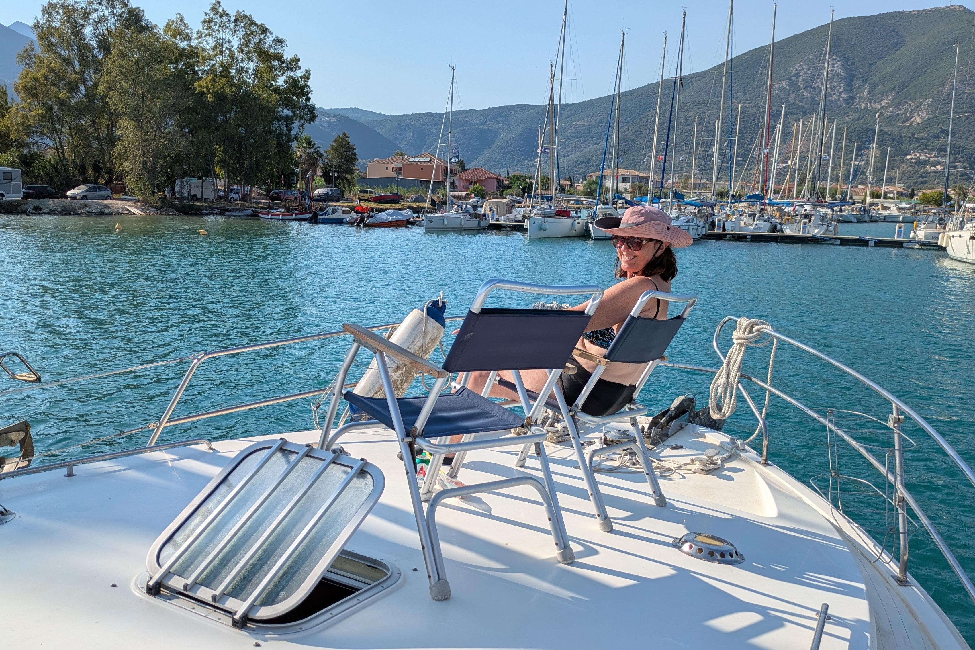 Woman relaxing on a 1987 Princess 385 yacht in a sunny marina.