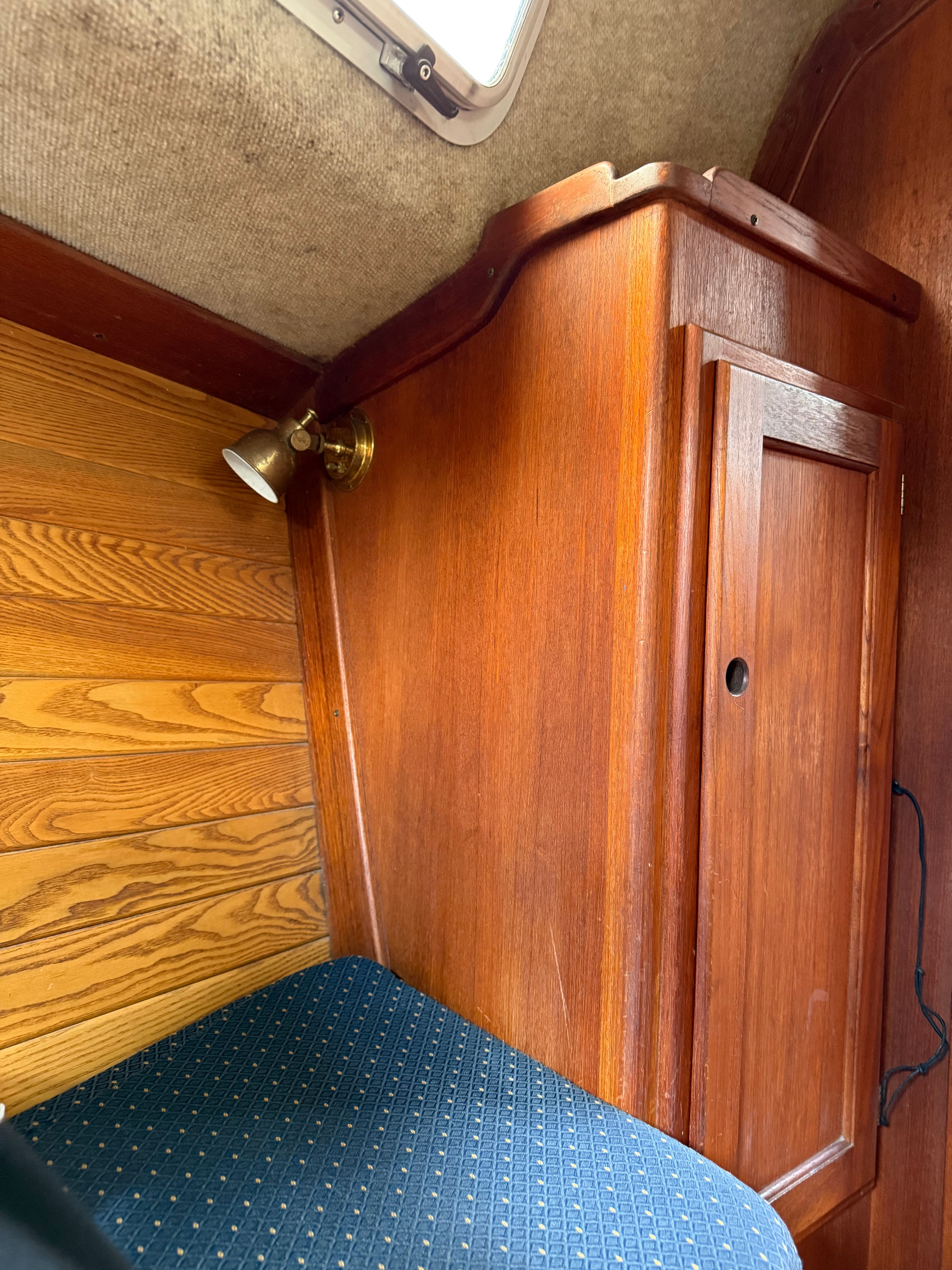 Interior of a yacht with wooden cabinetry and blue upholstery.
