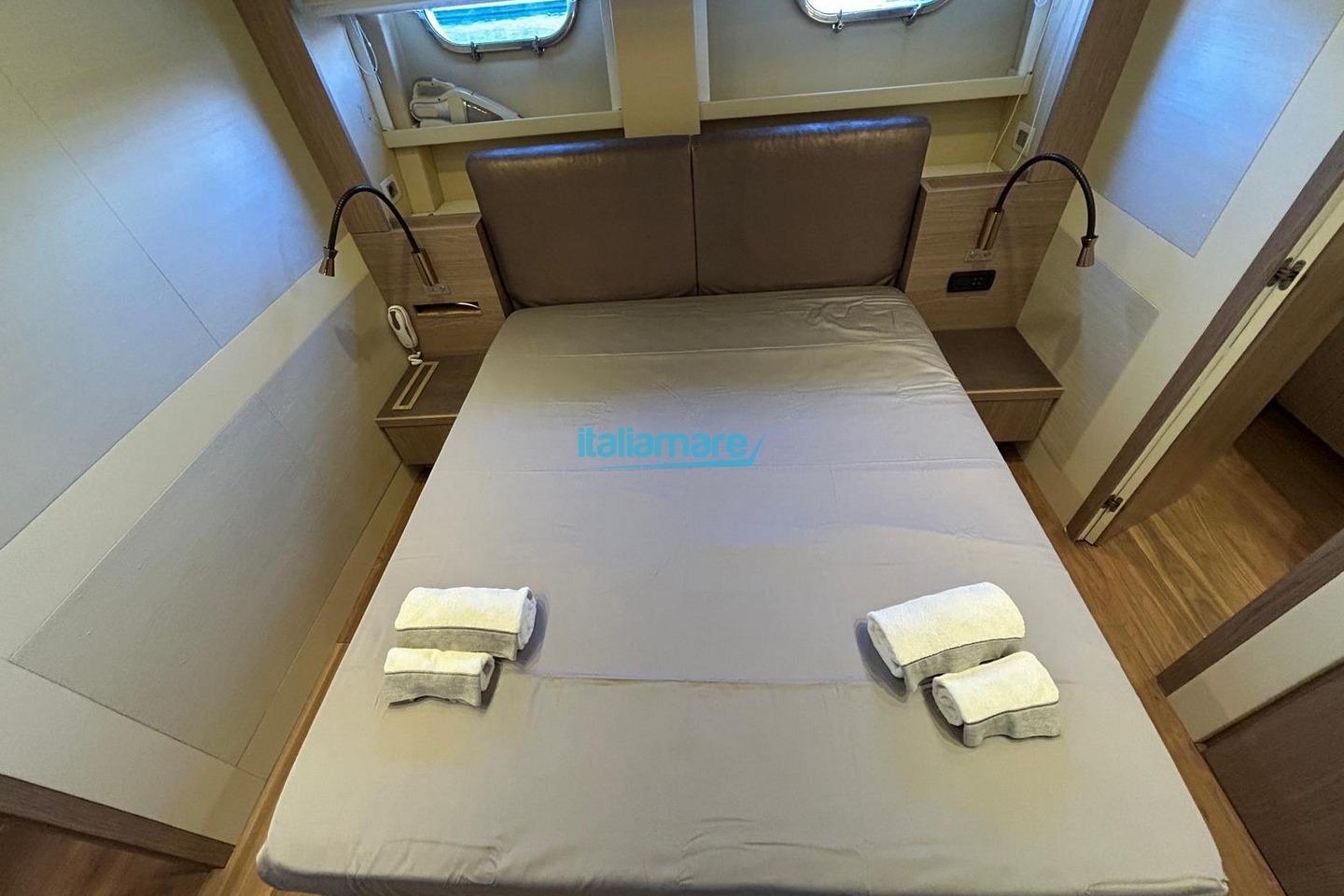 Luxurious cabin interior of 2009 PerMare Amer 92 yacht with neatly arranged bed and towels.