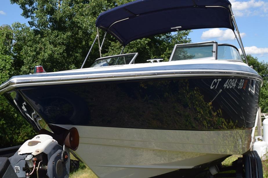 2006 Cobalt 240 boat with canopy, parked on trailer, surrounded by trees.