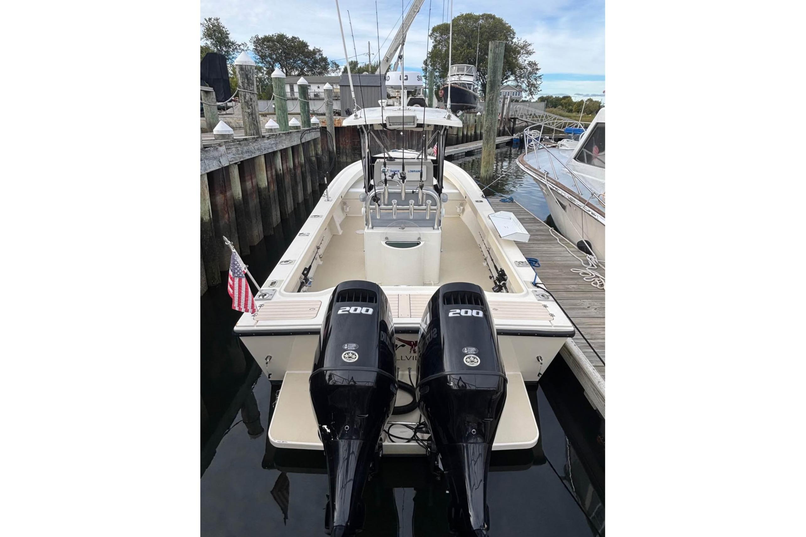 1999 Parker 2501 Center Console boat docked with twin 200 horsepower engines.