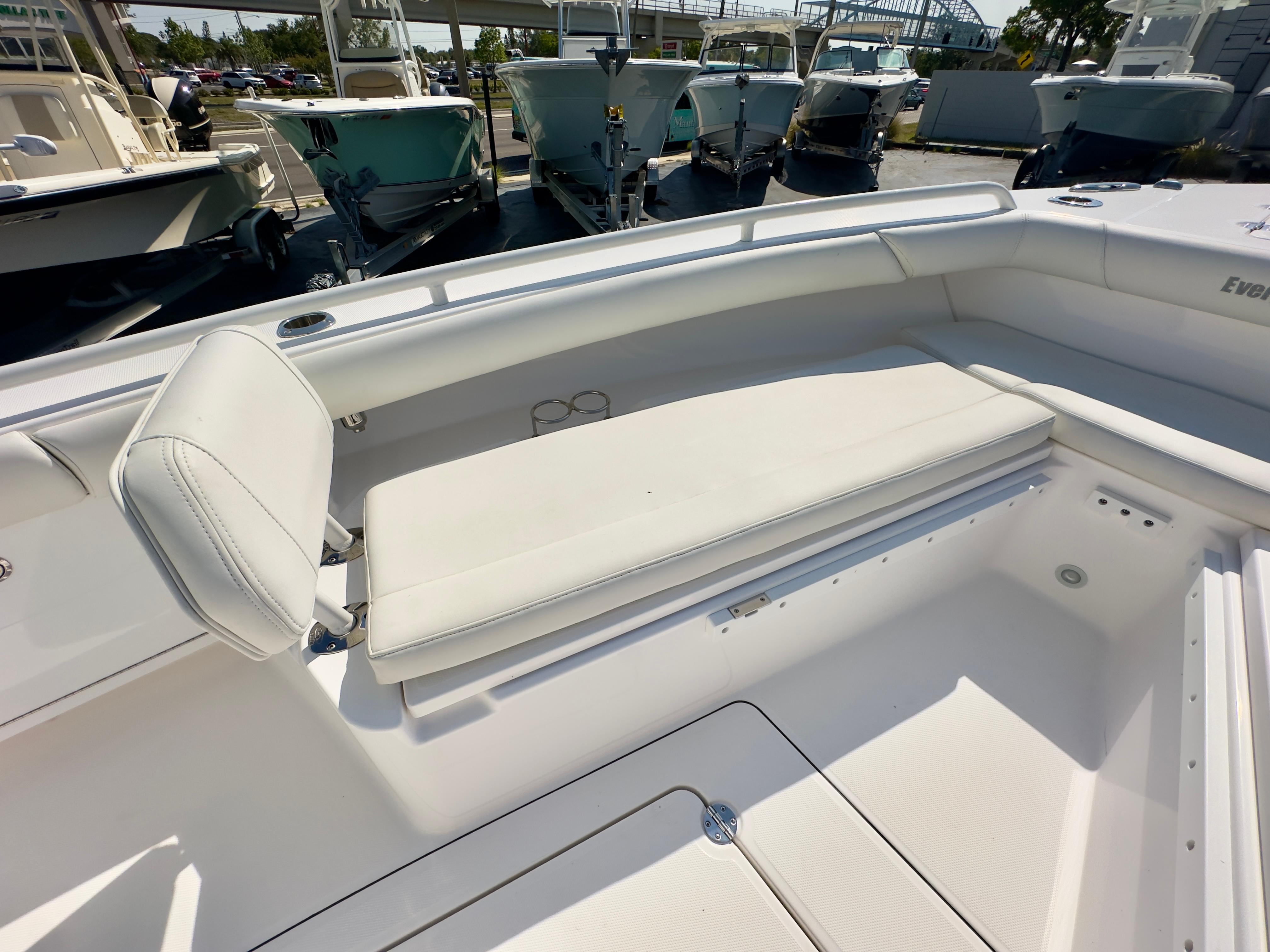 2023 Everglades 273 Center Console boat with white seating in a marina setting.