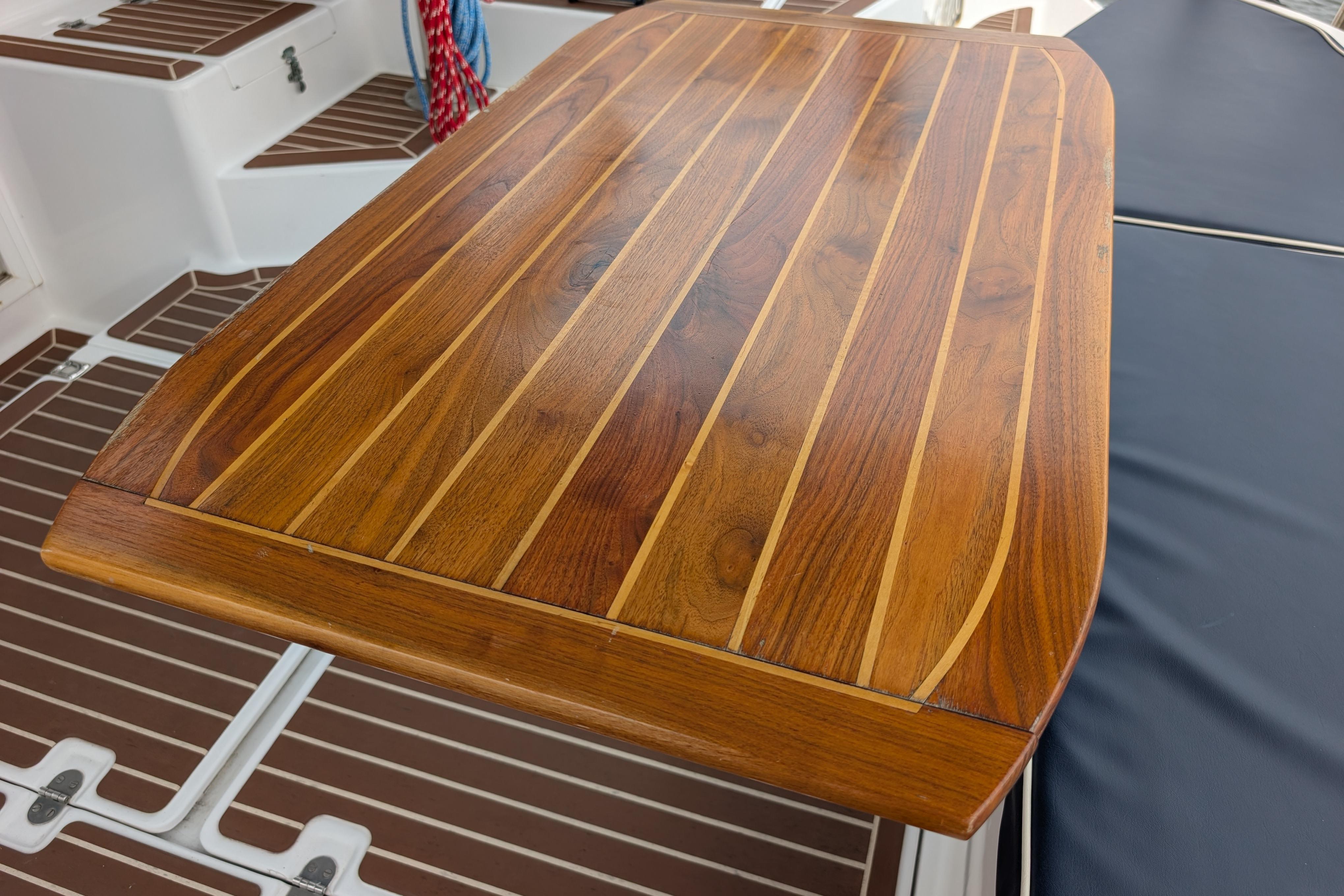 Teak table on 1999 Island Spirit 37 yacht, showcasing elegant wood grain design.
