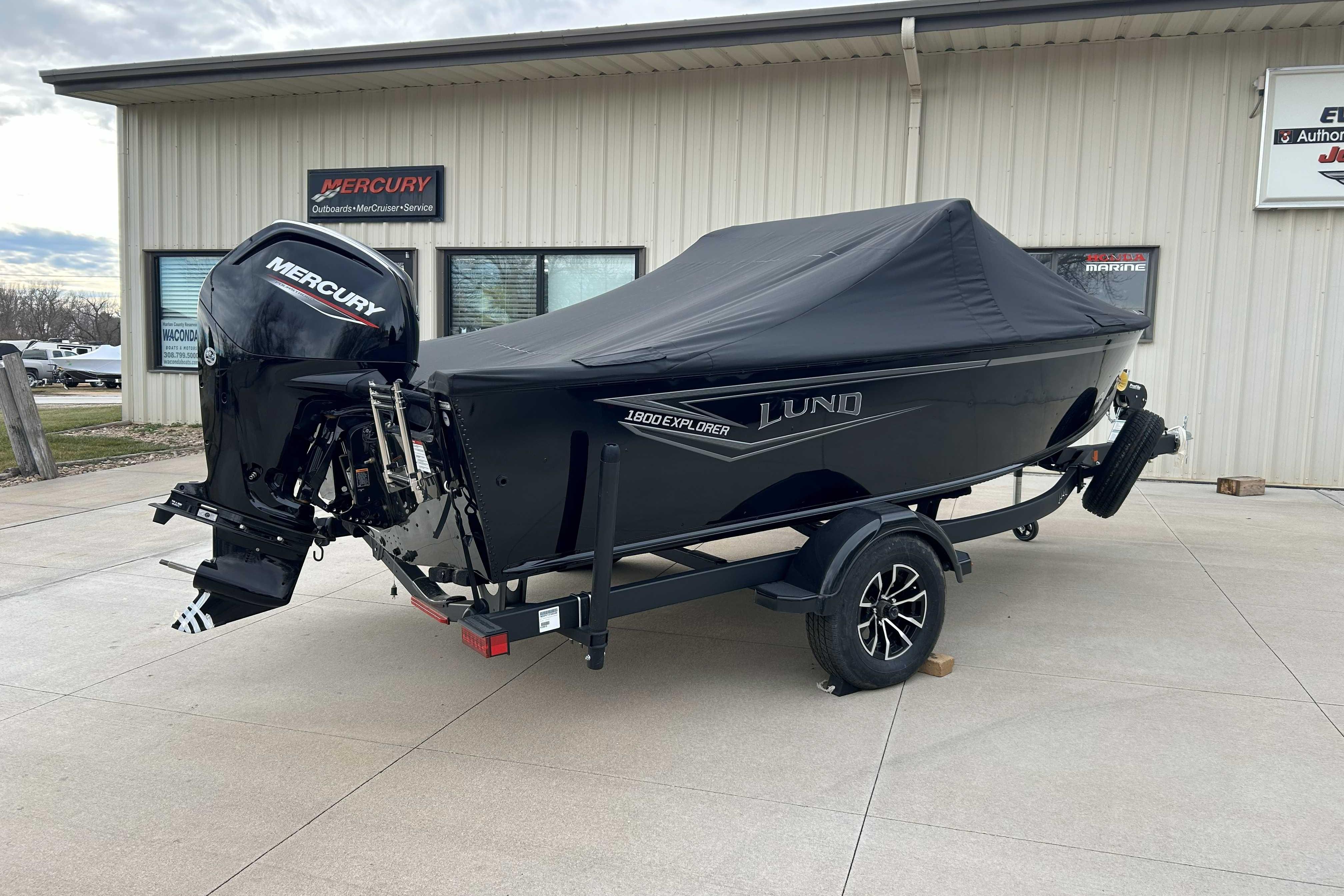 2026 Lund 1800 Explorer Sport boat with Mercury engine, covered and on trailer.