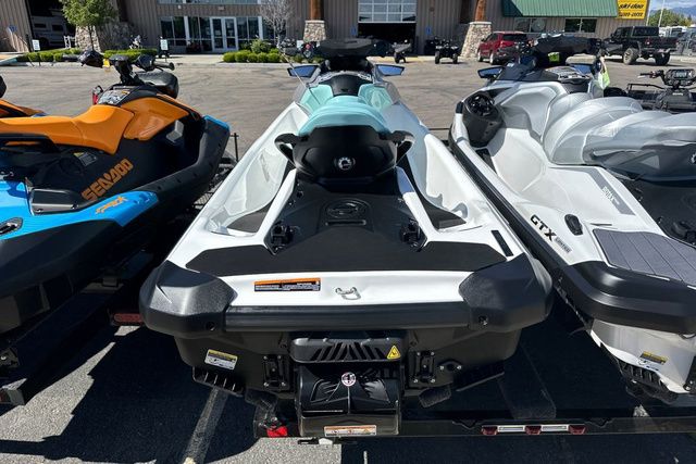 Three Sea-Doo jet skis are parked. The middle one is a GTI 130 WH IBR 26 STD.