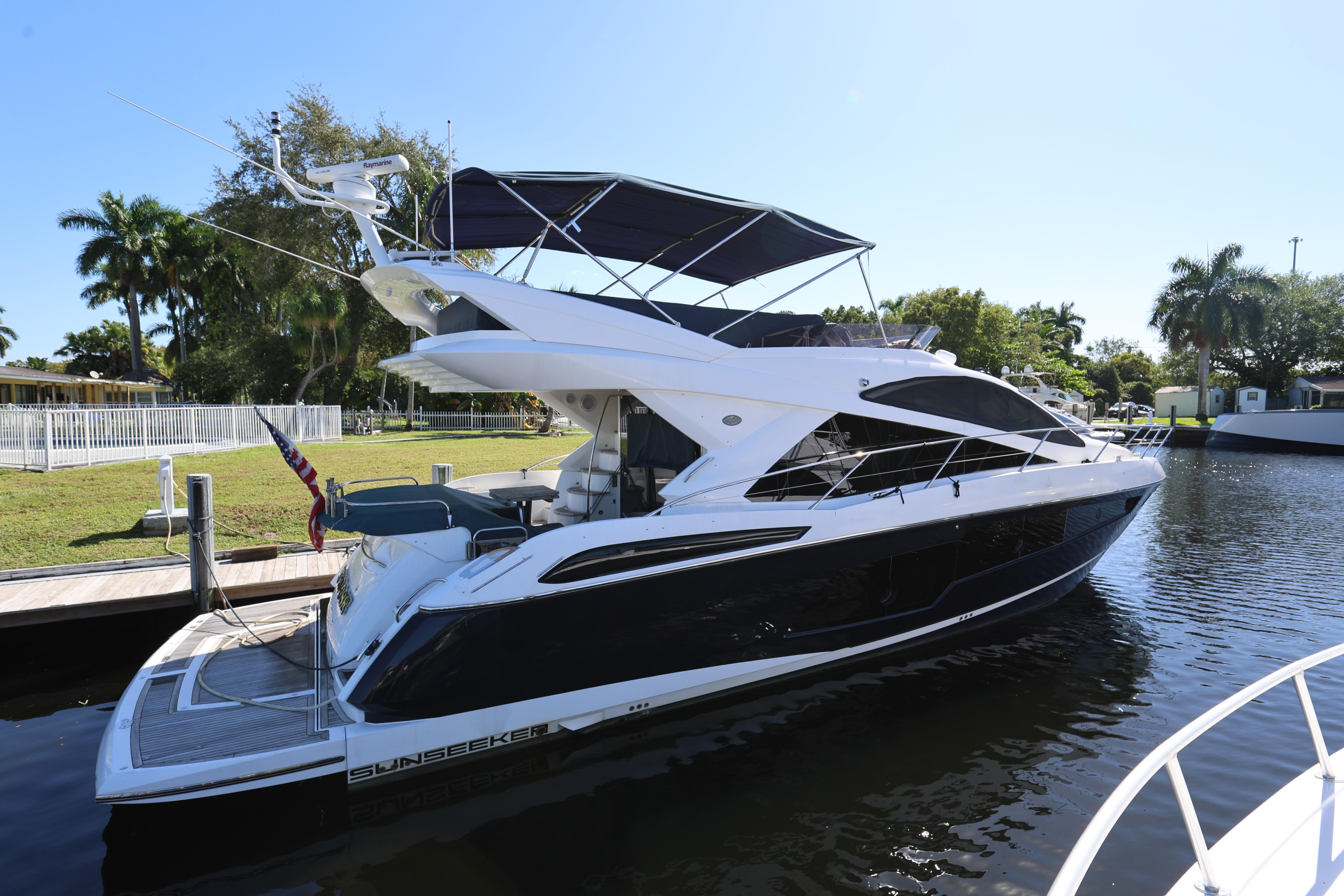 2016 Sunseeker Manhattan 55 yacht docked by a lush, tropical waterfront.