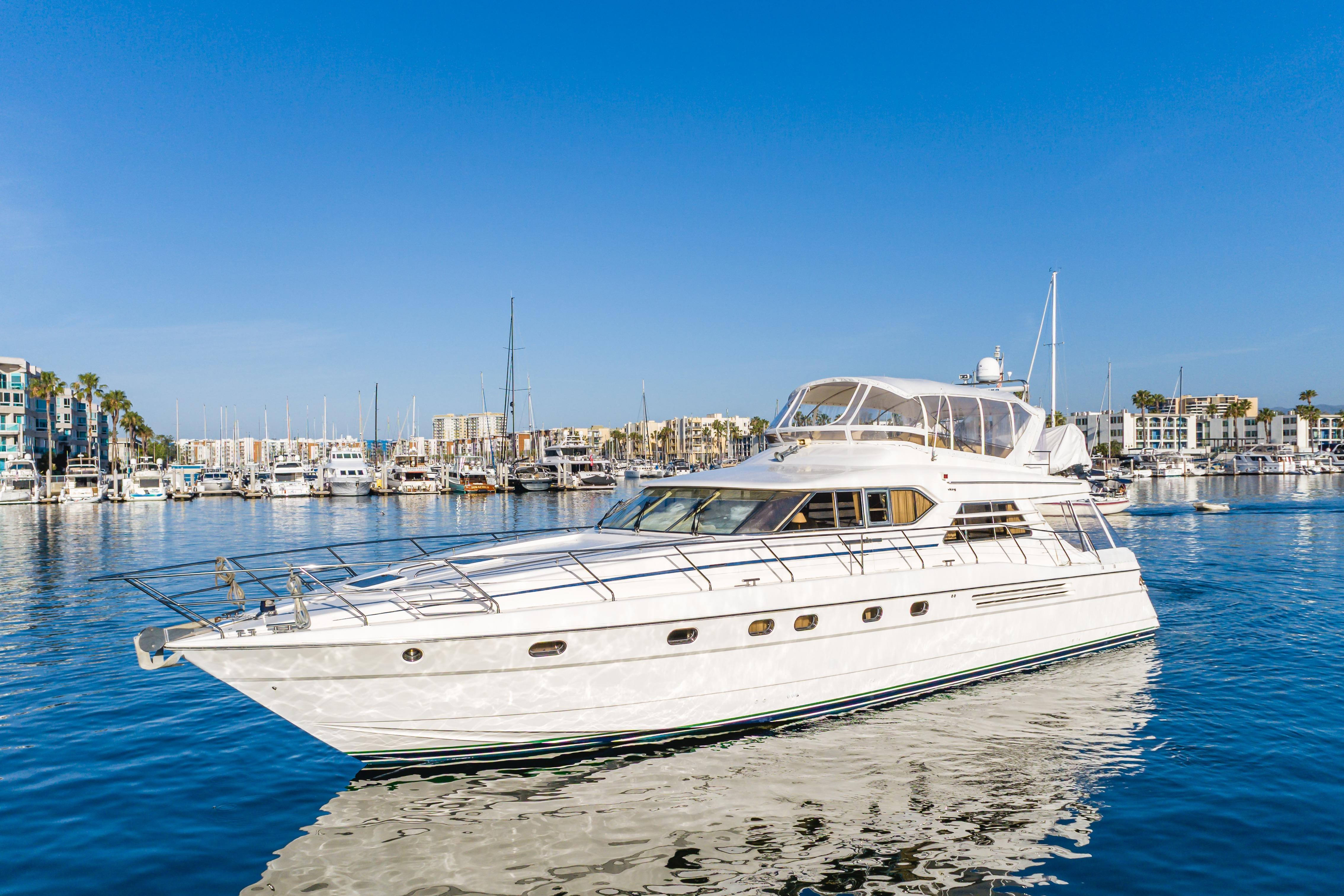 1997 Viking Sport Cruisers 66 Motor Yacht docked in a sunny marina.