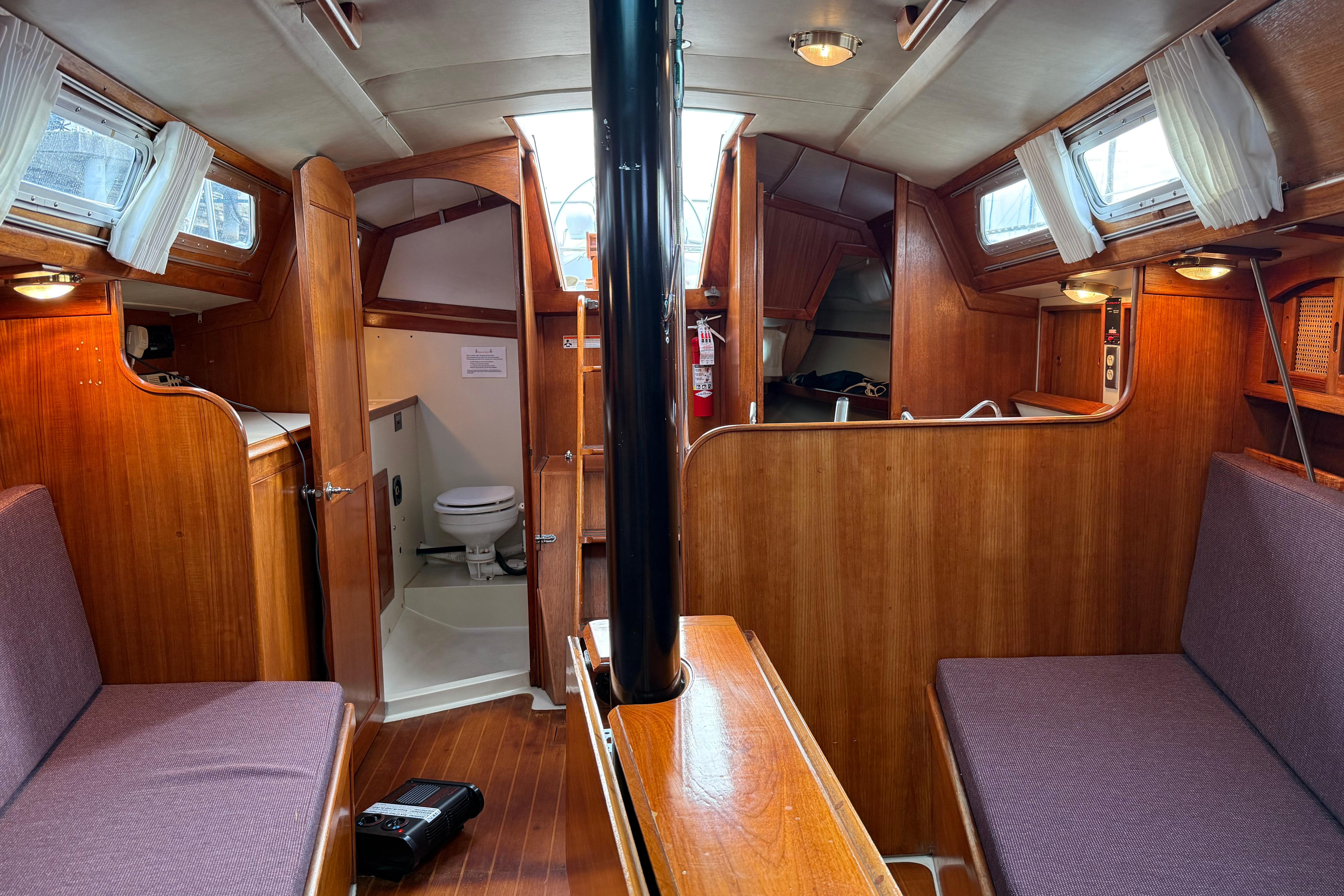 Interior of 1988 Ericson 32-200 sailboat with wood finish and cozy seating.