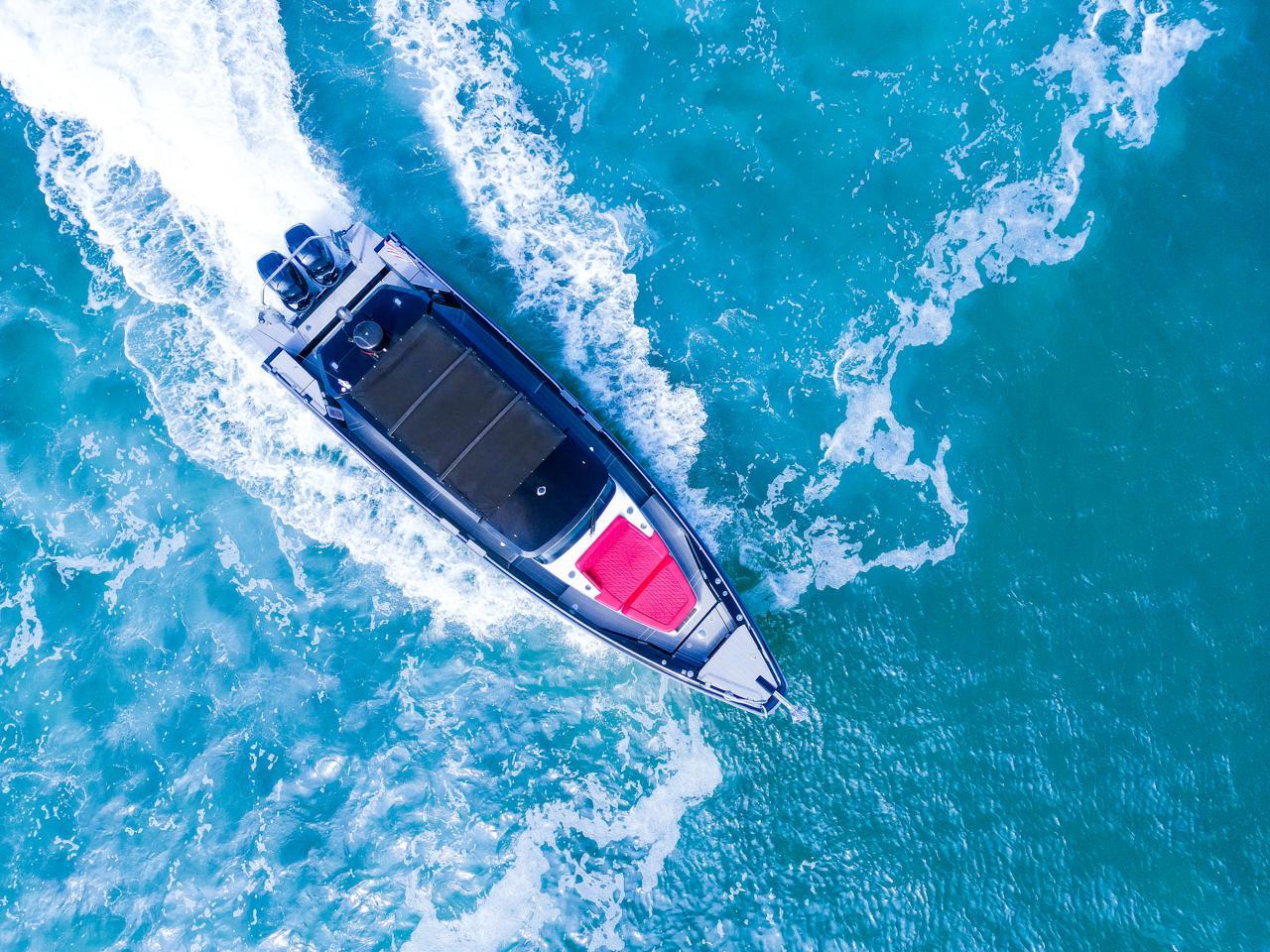 Aerial view of 2018 Axopar 37 Sun Top cruising on vibrant blue ocean waters.