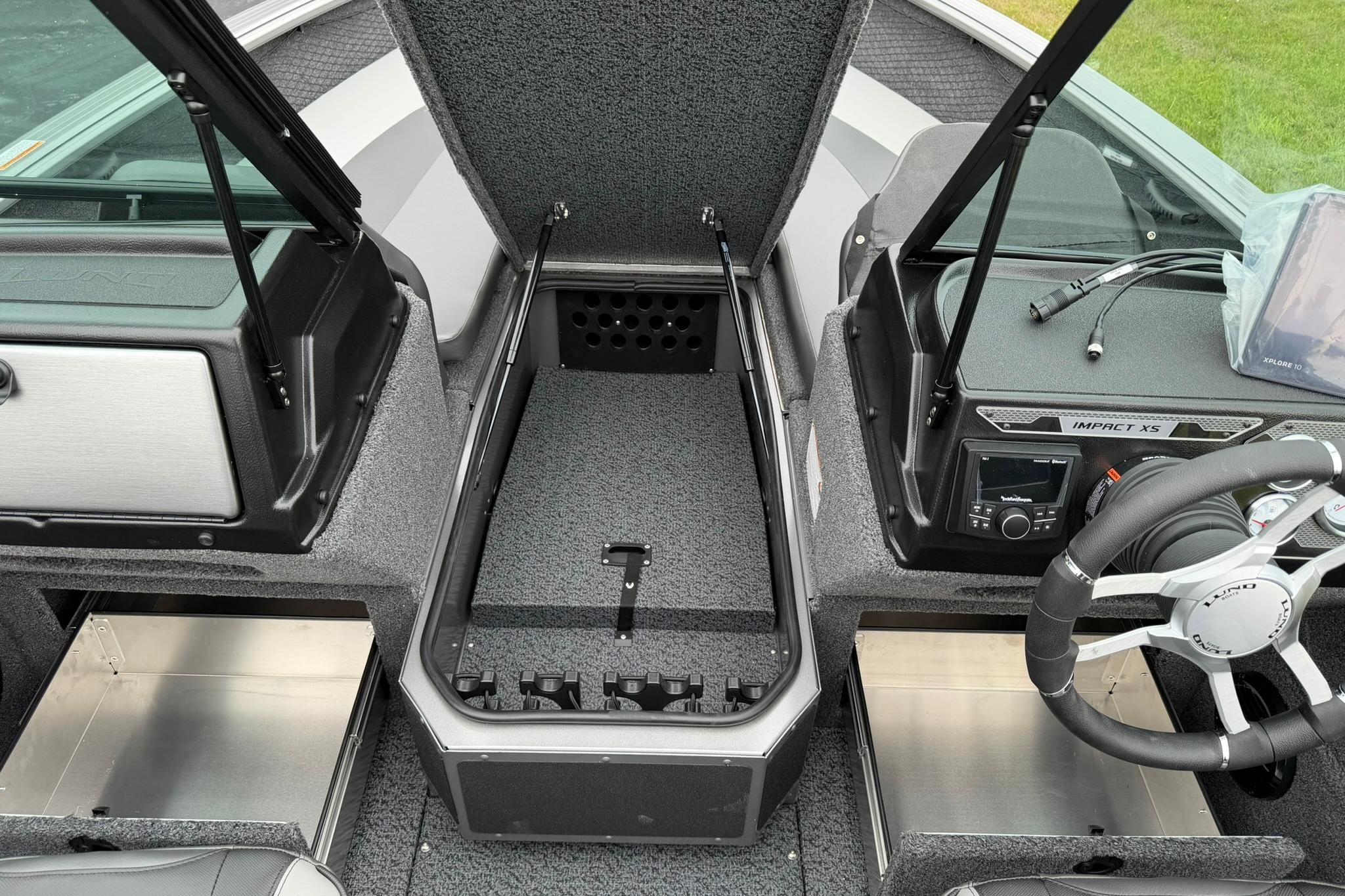 2027 Lund 2075 Impact XS boat interior with steering wheel, storage compartments, and control panel.
