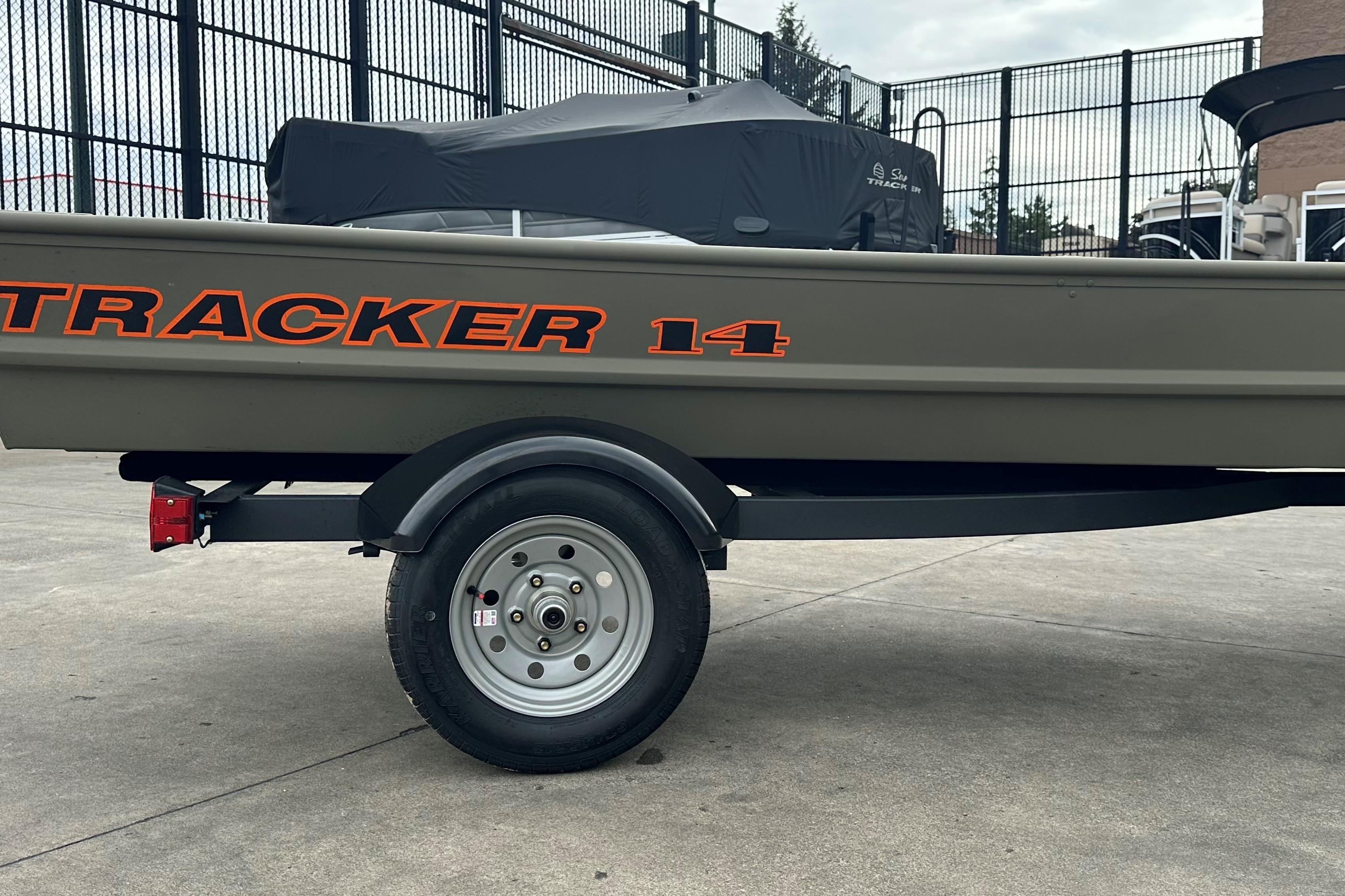 2026 Tracker Grizzly 14 Jon boat on trailer, parked outdoors.