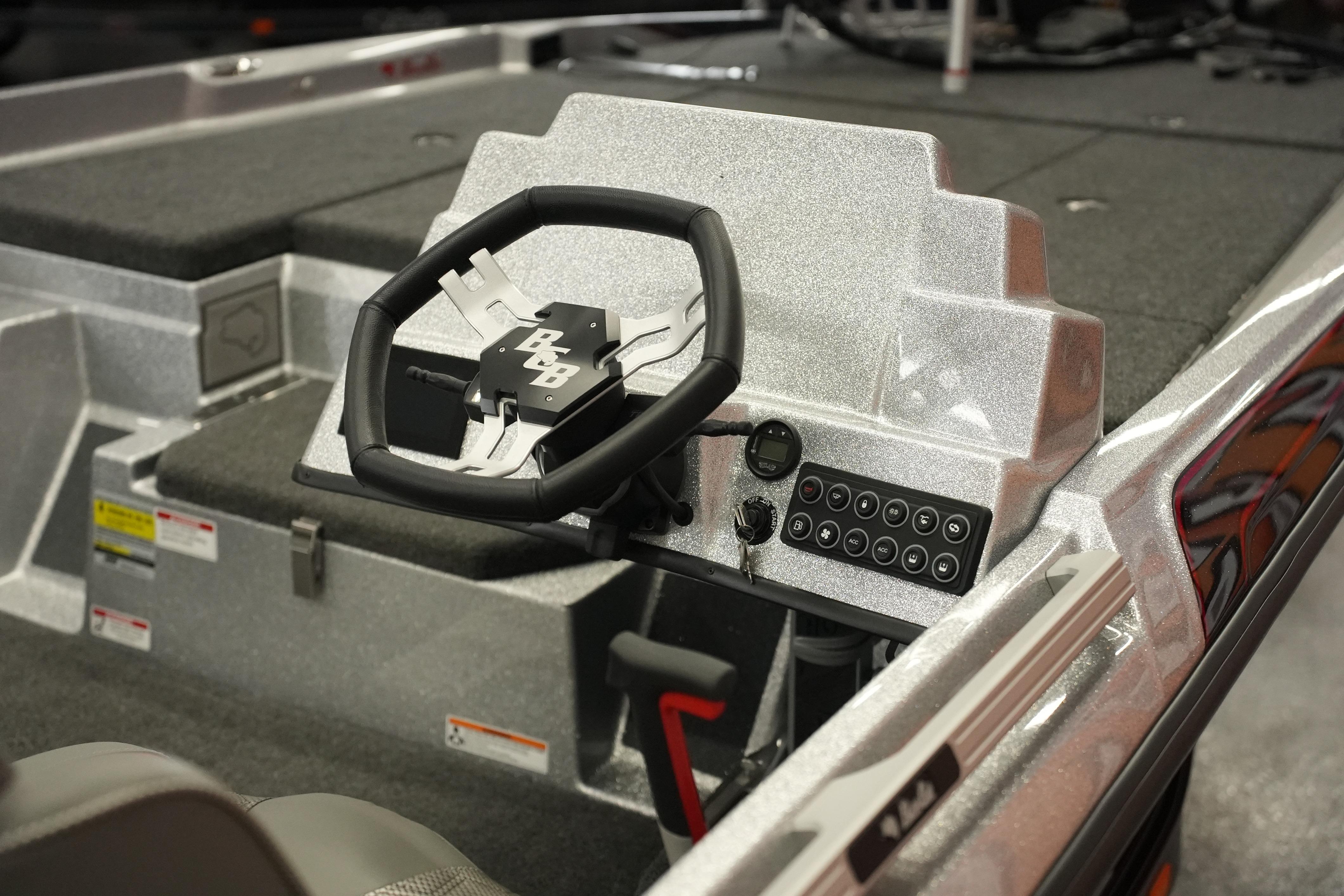 2026 Bass Cat Lynx STS boat dashboard with steering wheel and control panel.