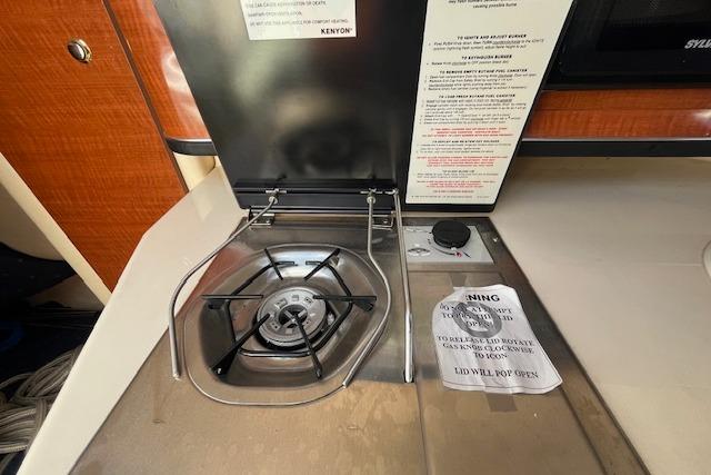 2003 Sea Ray 260 Sundancer boat stove with safety instructions and control knob.