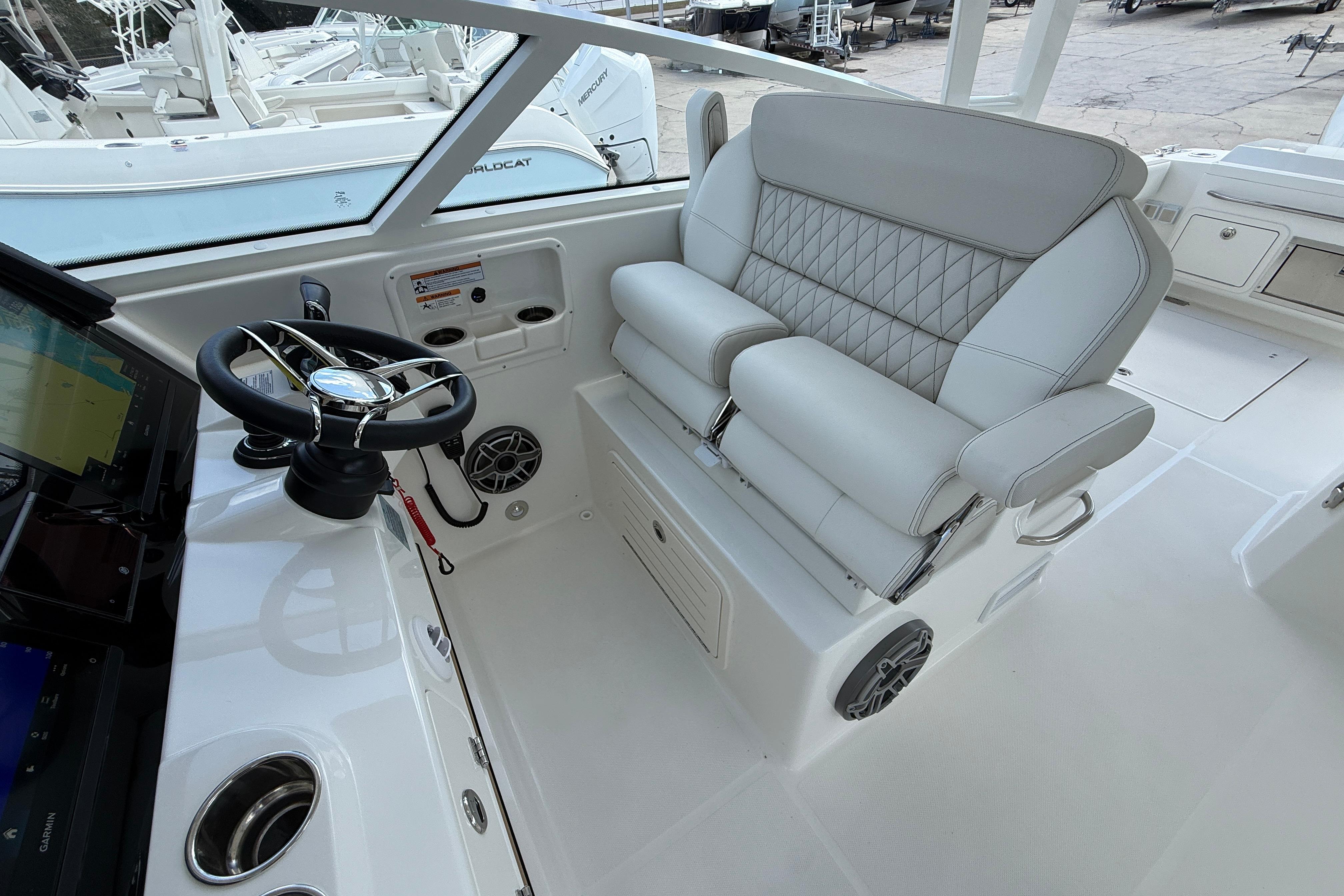 2026 World Cat 400 DC-X Island boat interior with steering wheel and luxurious seating.
