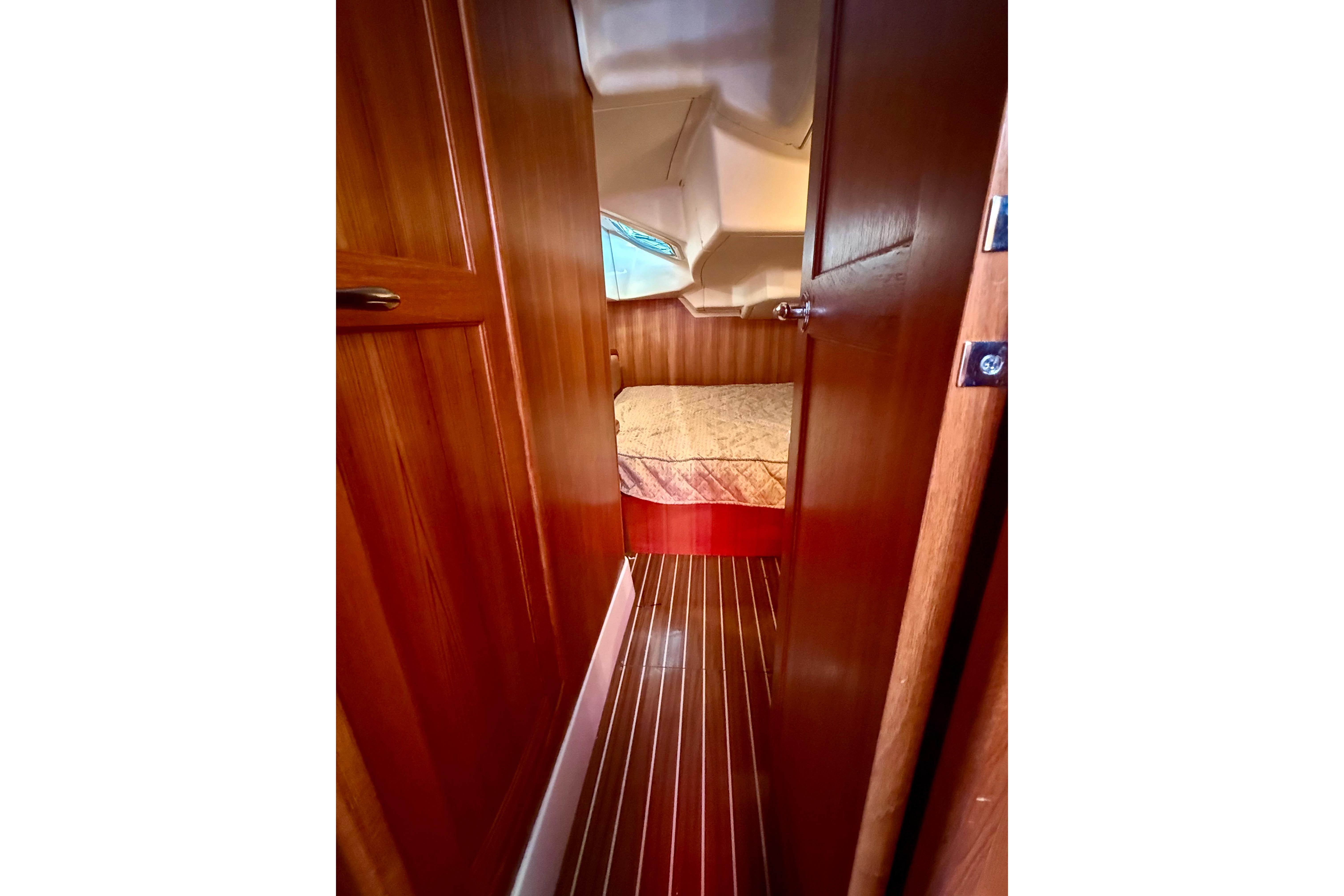 Interior view of 2007 Hunter 41 Deck Salon, featuring wooden cabin and cozy bed.