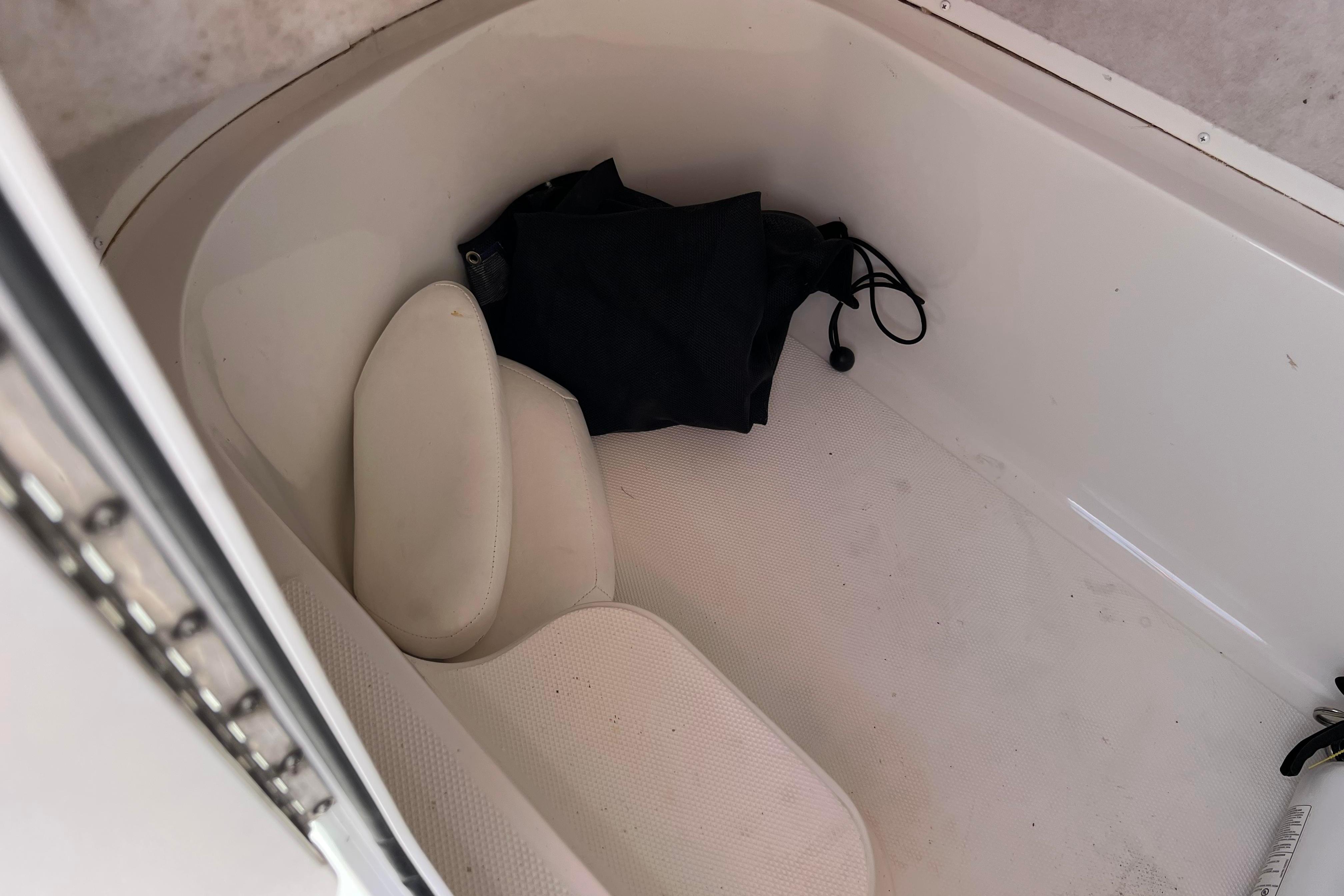 Storage compartment in a 2012 Sea Fox 206 Center Console boat with cushions and bag.