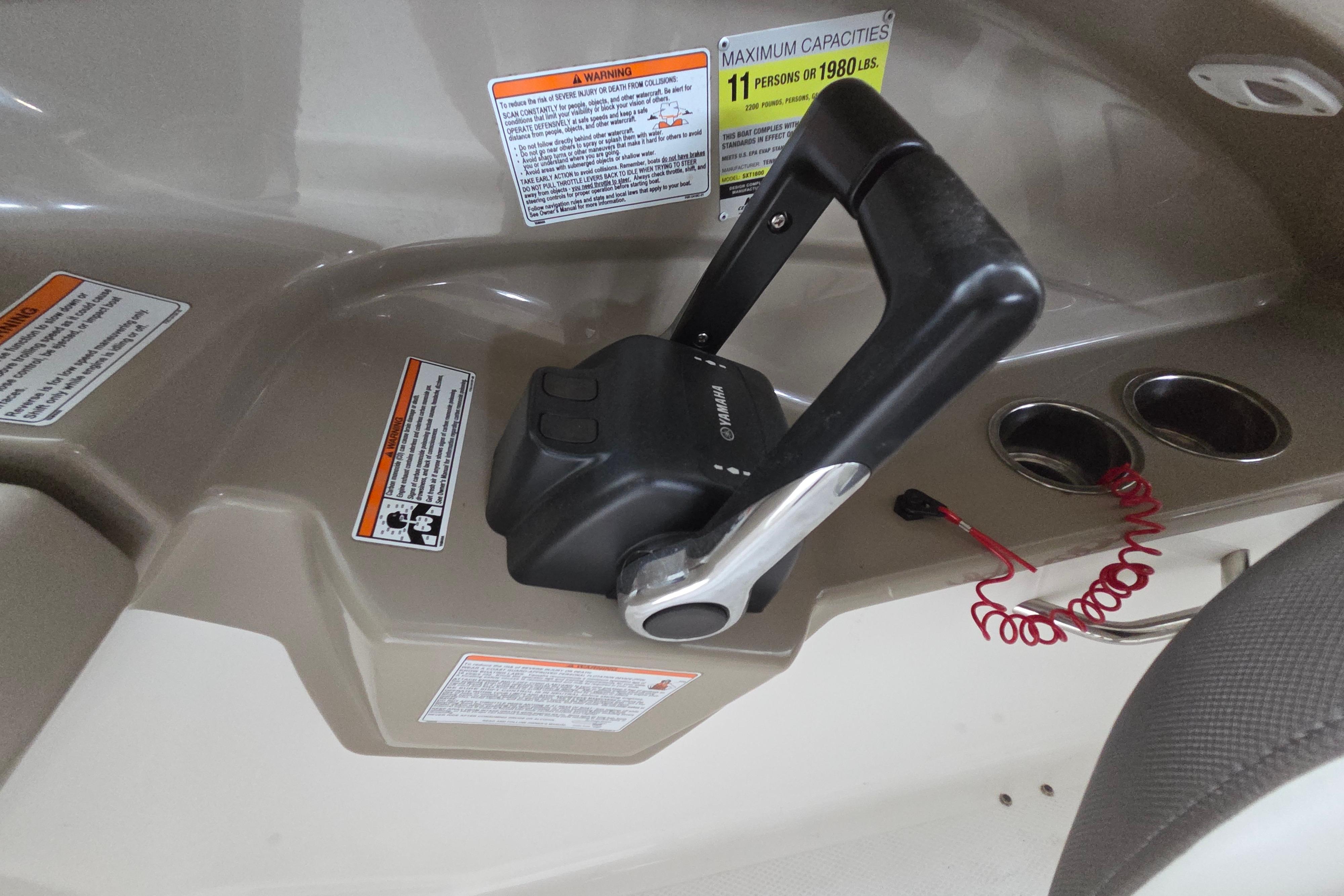 Yamaha 242 Limited S 2013 throttle control with warning labels and cup holders.