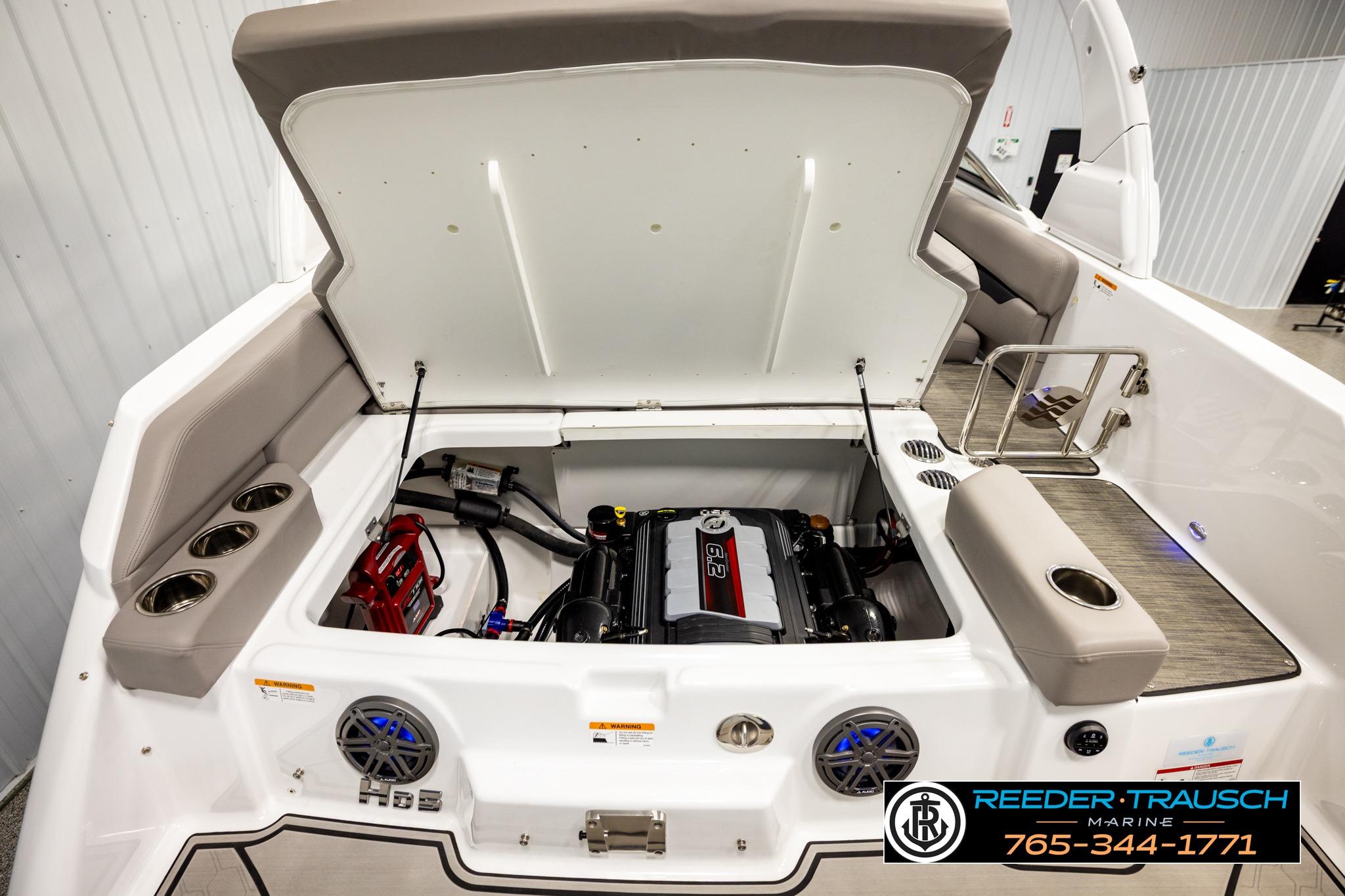 2024 FOURWINNS HD5 Surf boat engine compartment with open hatch and seating area.