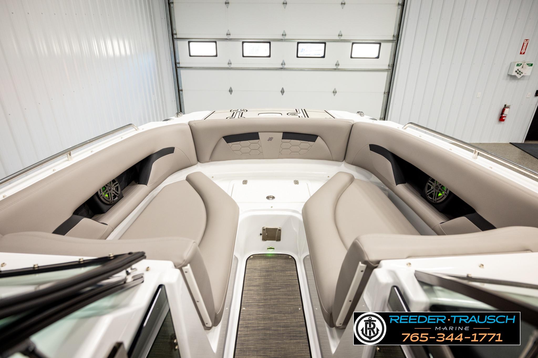 2024 FOURWINNS HD5 Surf boat interior with beige seating in a showroom.