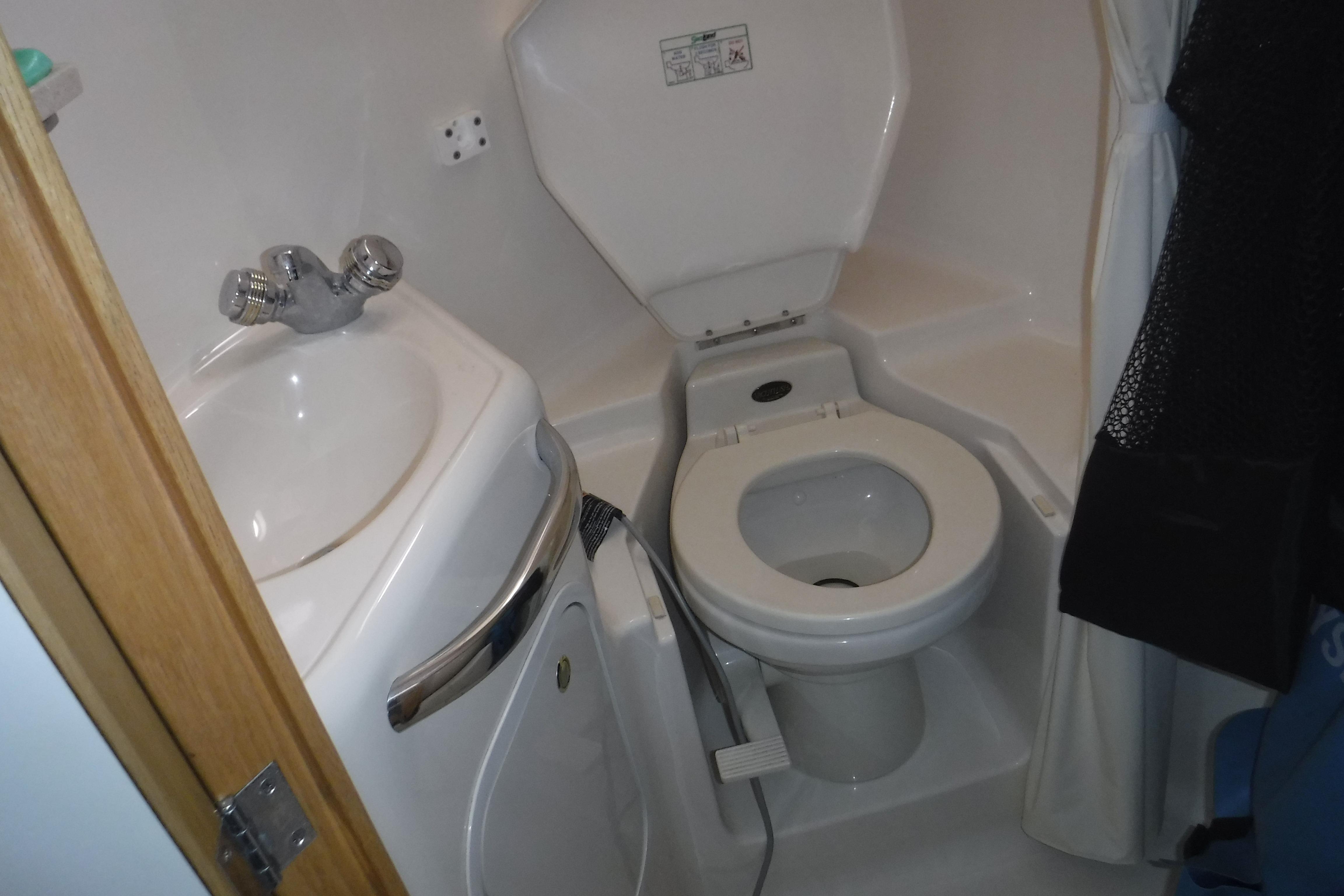 Bathroom interior of 1997 Sea Ray 450 Sundancer yacht, featuring sink and toilet.