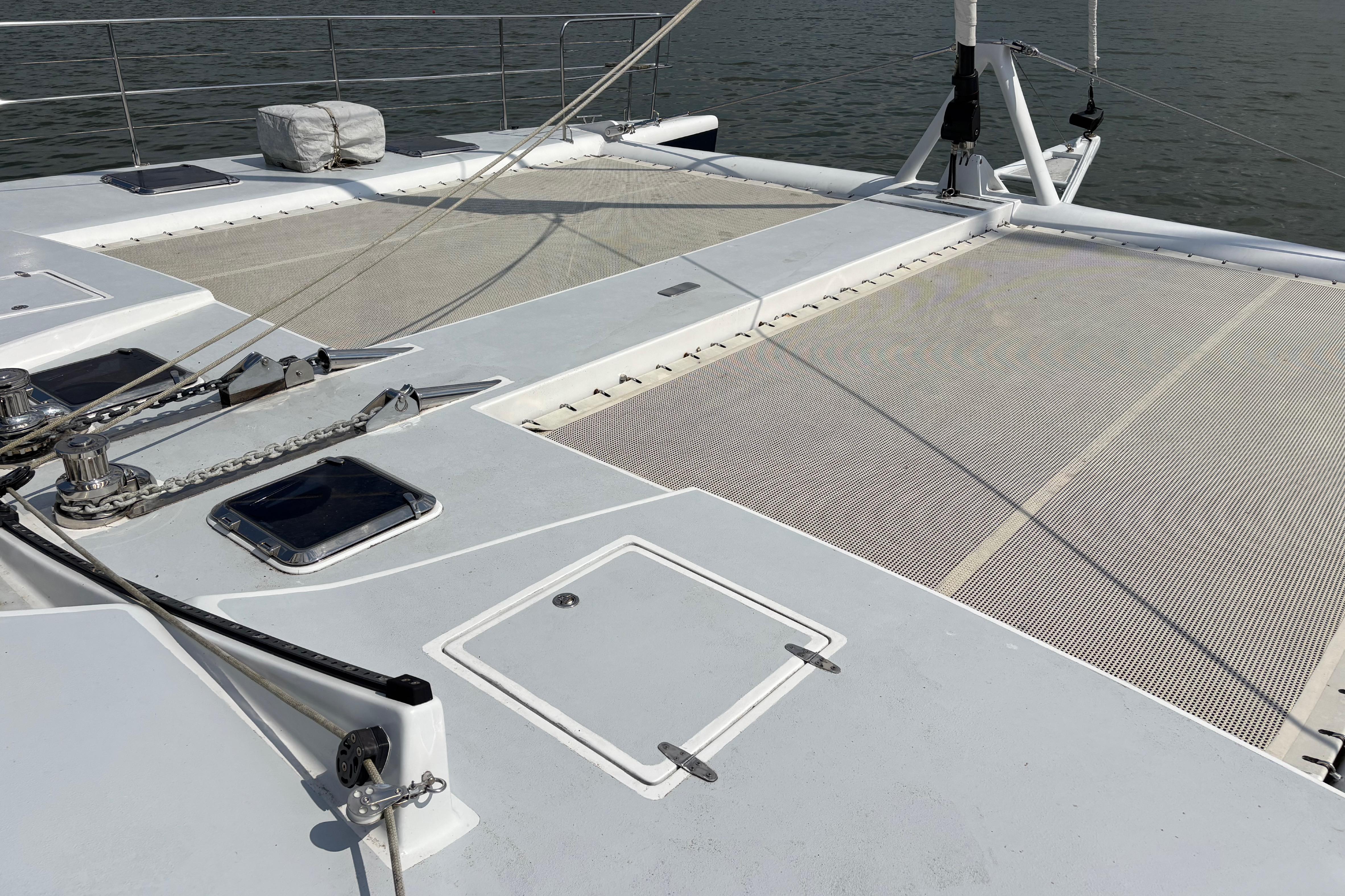 2006 Lidgard Custom Catamaran deck with netting and hatches, anchored on calm water.