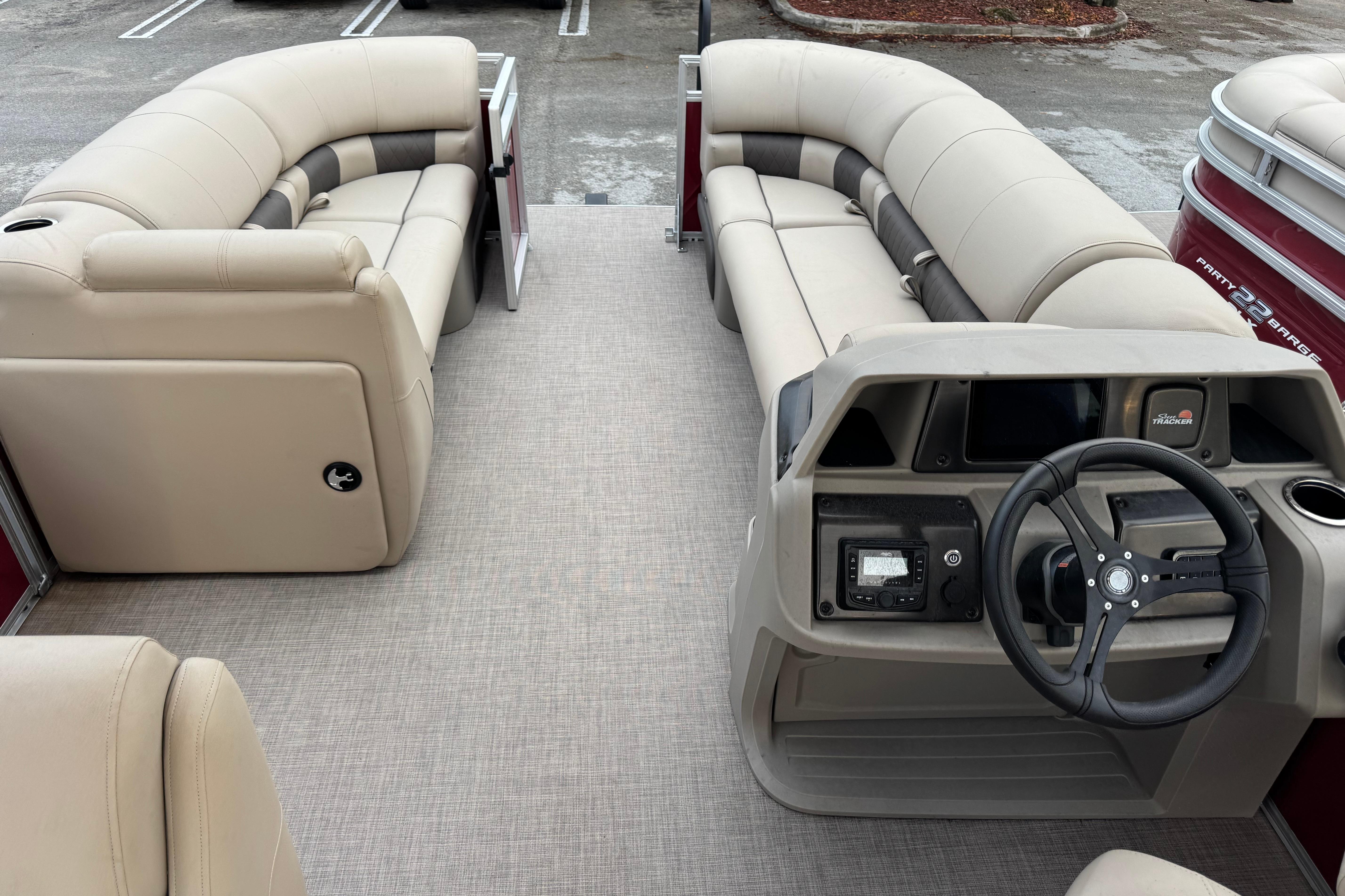 2025 Sun Tracker Party Barge 20 DLX interior with beige seating and steering console.