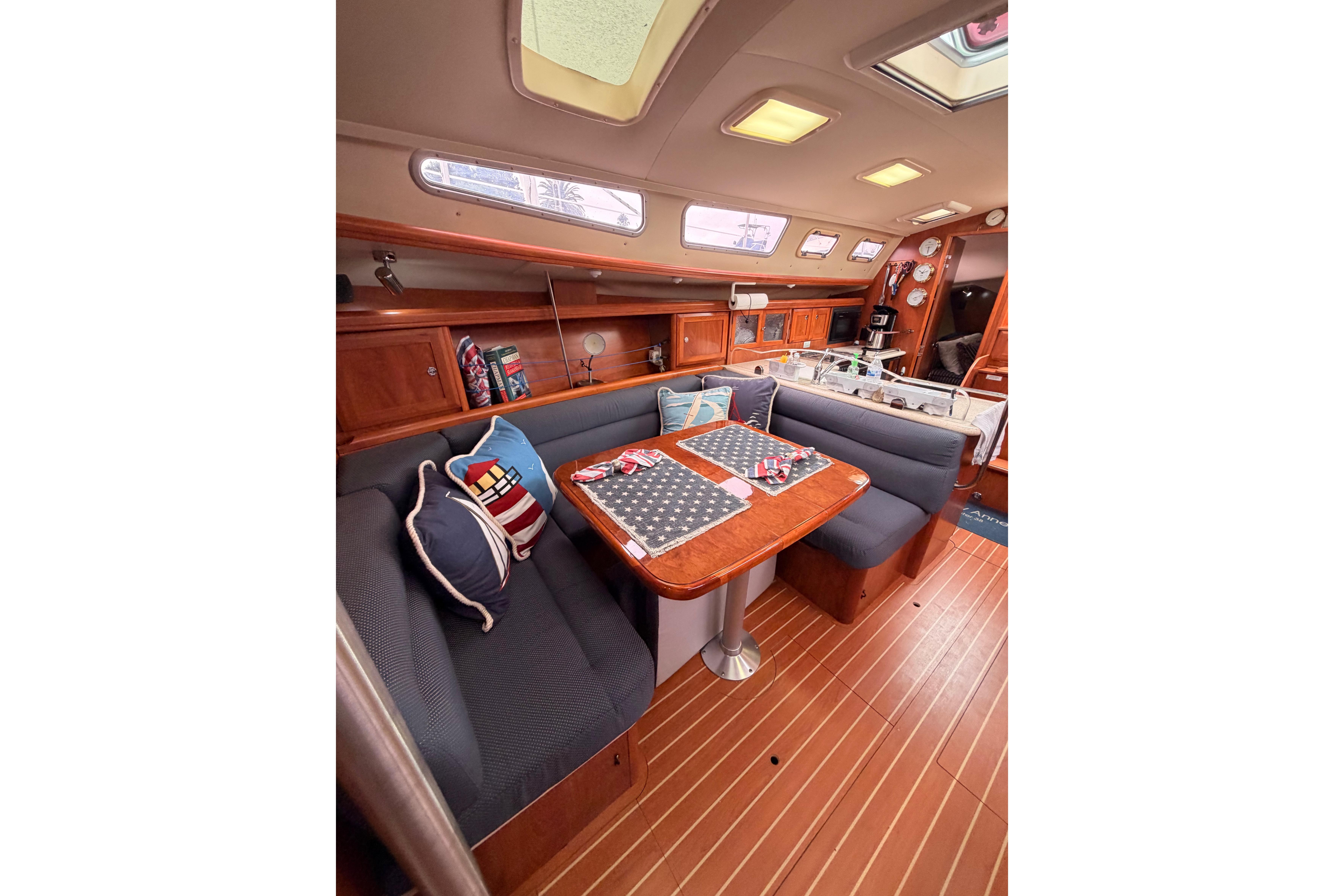 Luxurious interior of 2009 Hunter 38 sailboat with cozy seating and elegant wood finishes.