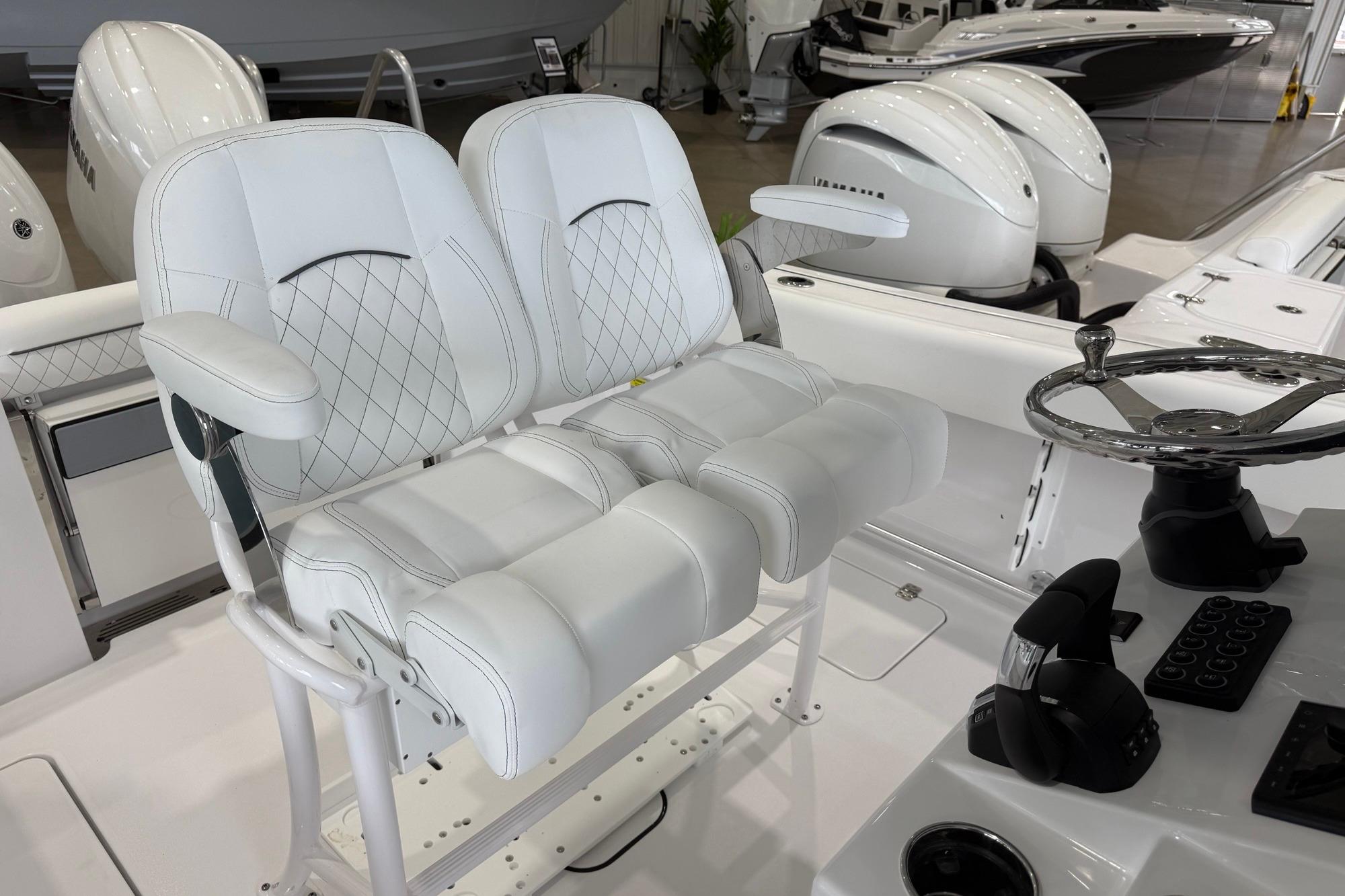 2026 Sportsman Open 252 Center Console boat with dual white cushioned seats and steering wheel.