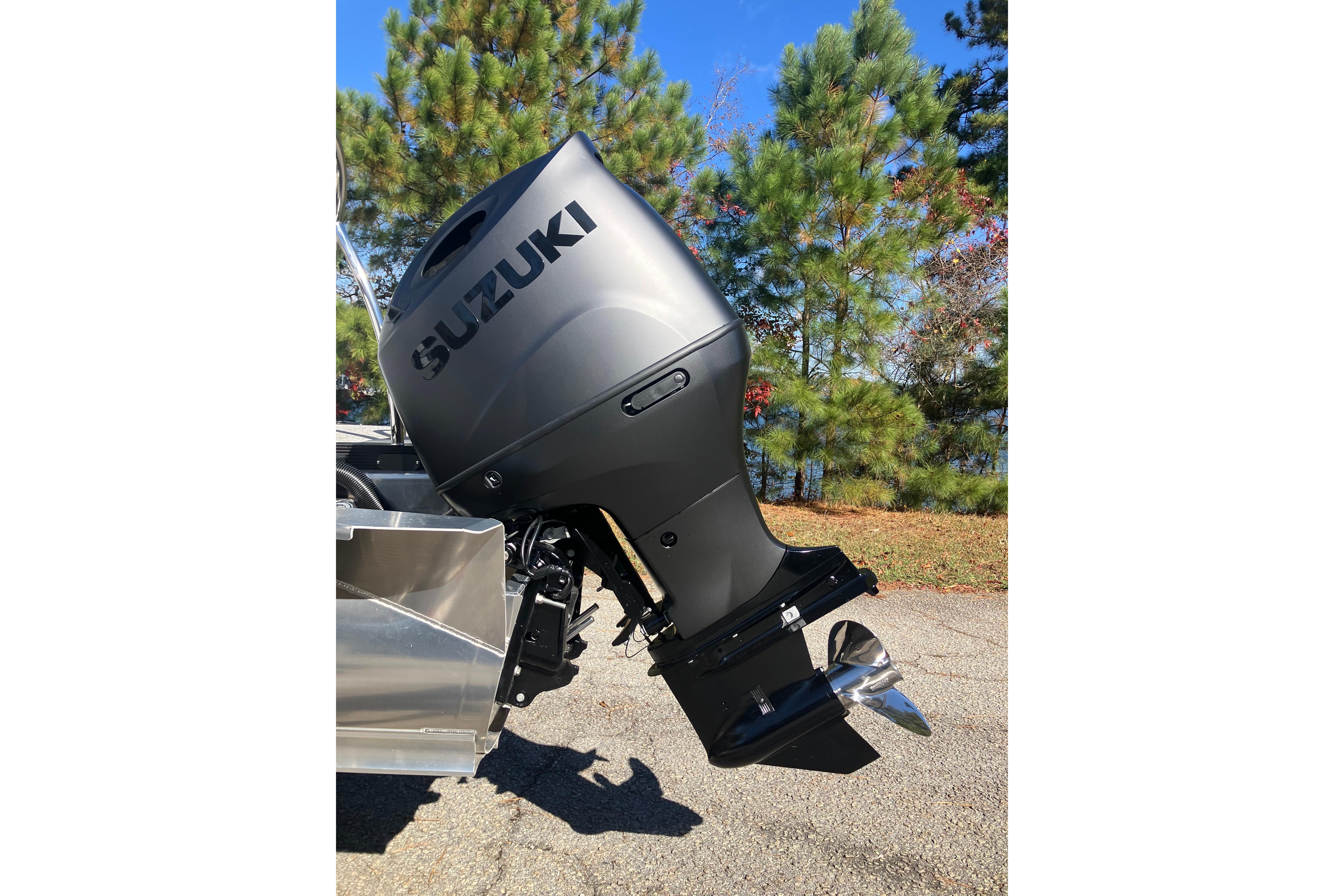 2026 Tahoe Pontoon LTZ Quad Lounger with Suzuki outboard motor, parked outdoors.