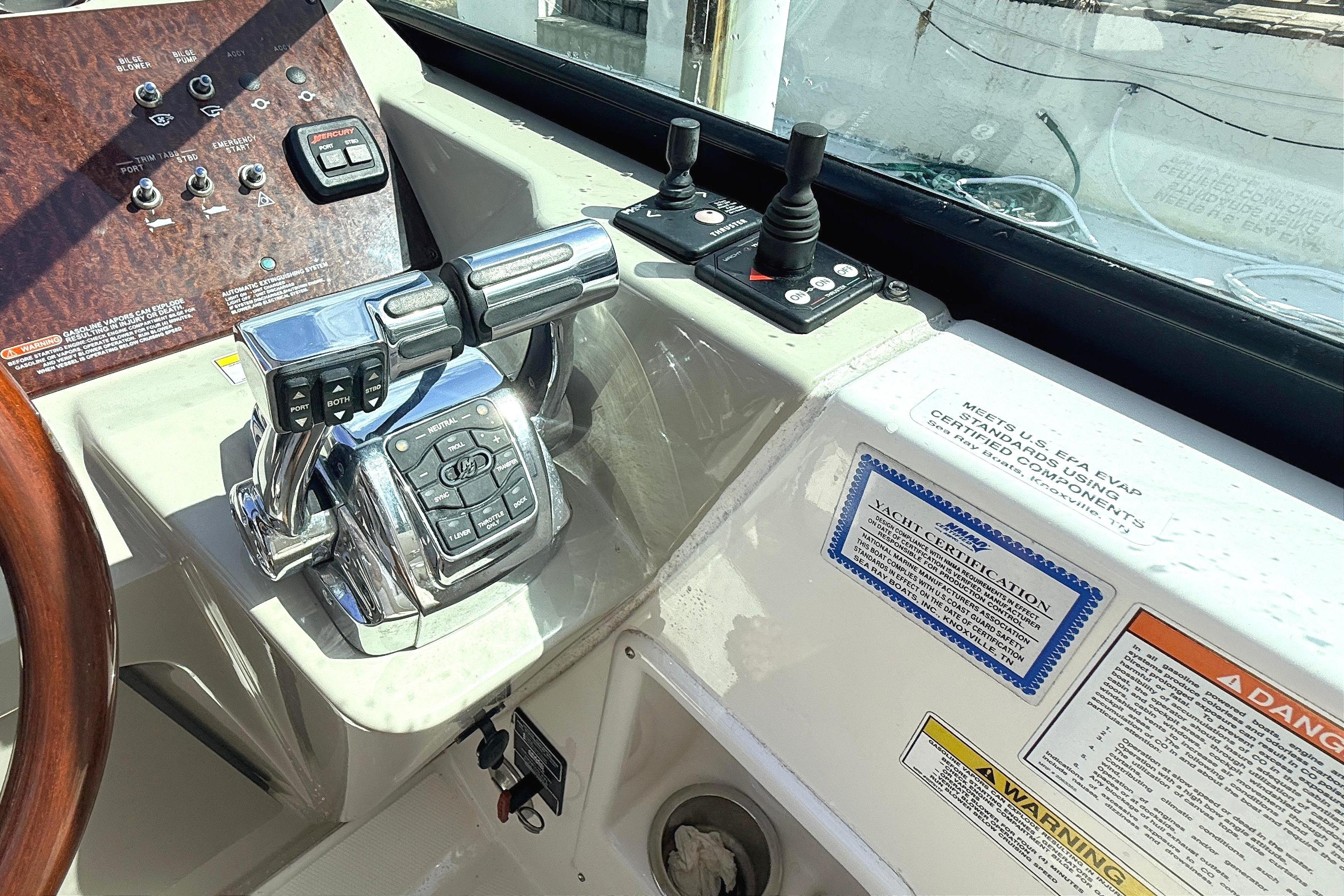 Control panel of a 2013 Sea Ray 370 Venture boat with steering wheel and throttle controls.