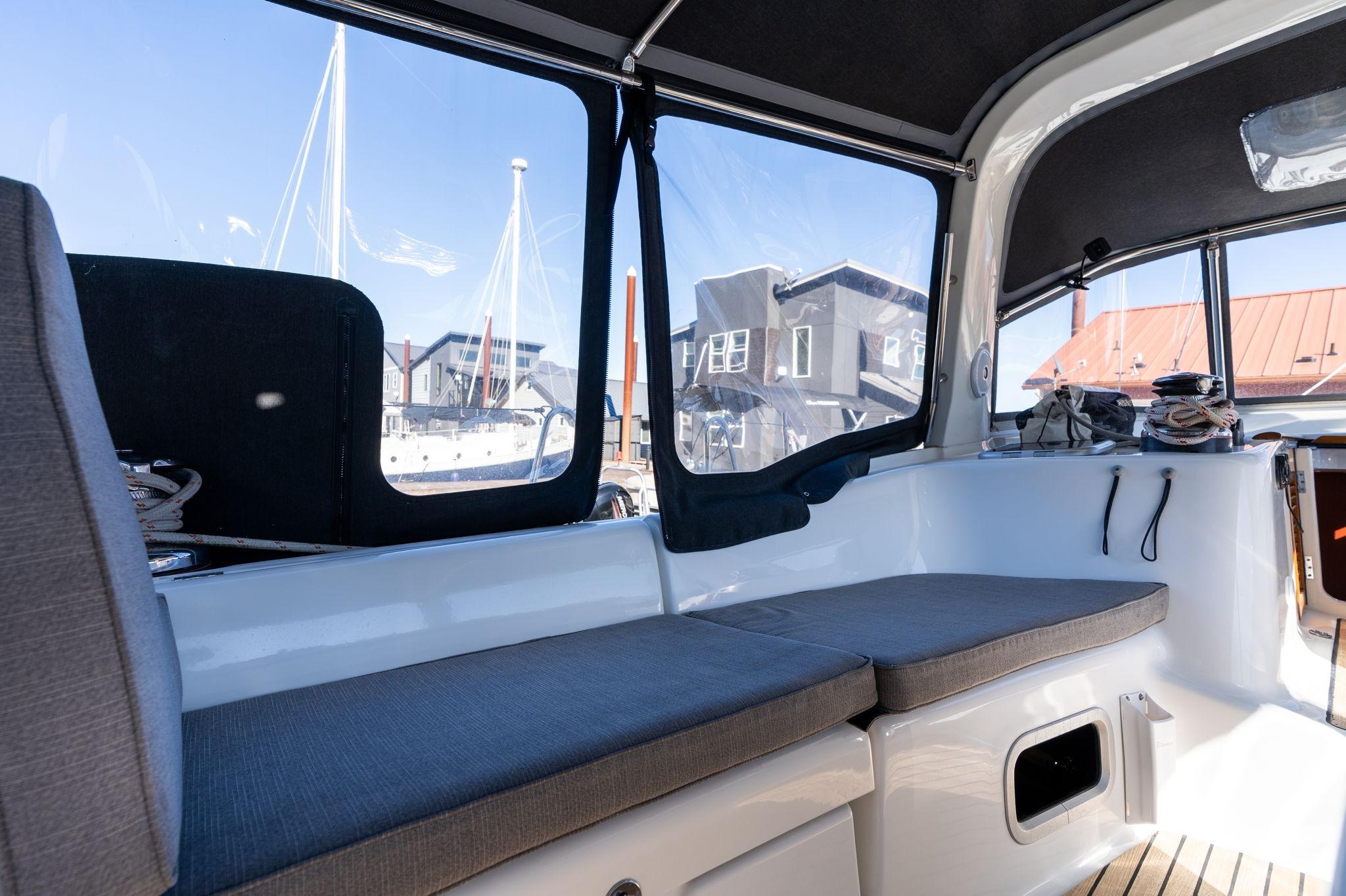 Interior view of 2013 Beneteau Oceanis 50 sailboat with cushioned seating and marina backdrop.