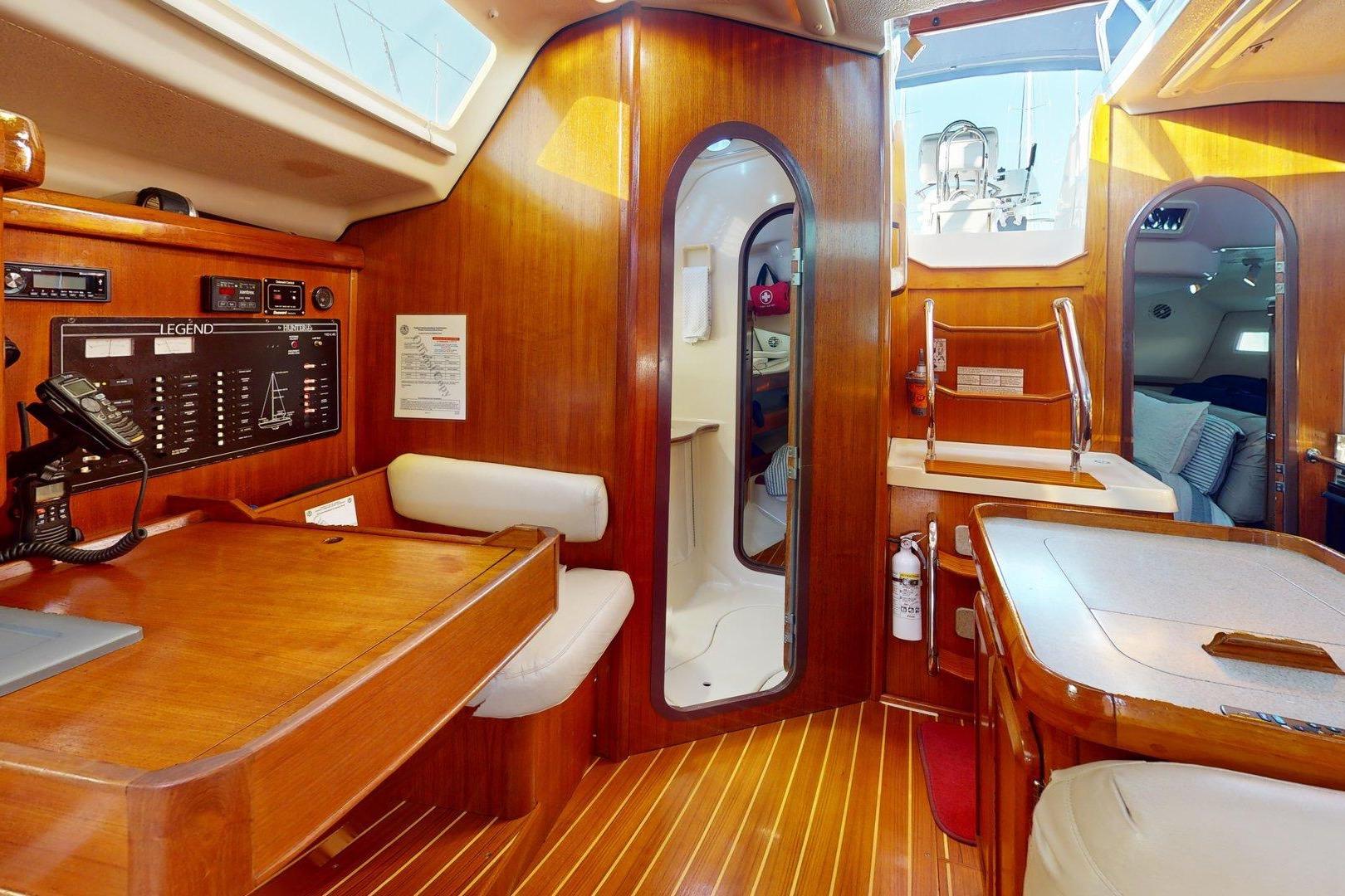 Interior of a 1997 Hunter Legend 40.5 sailboat with wood finish and navigation station.