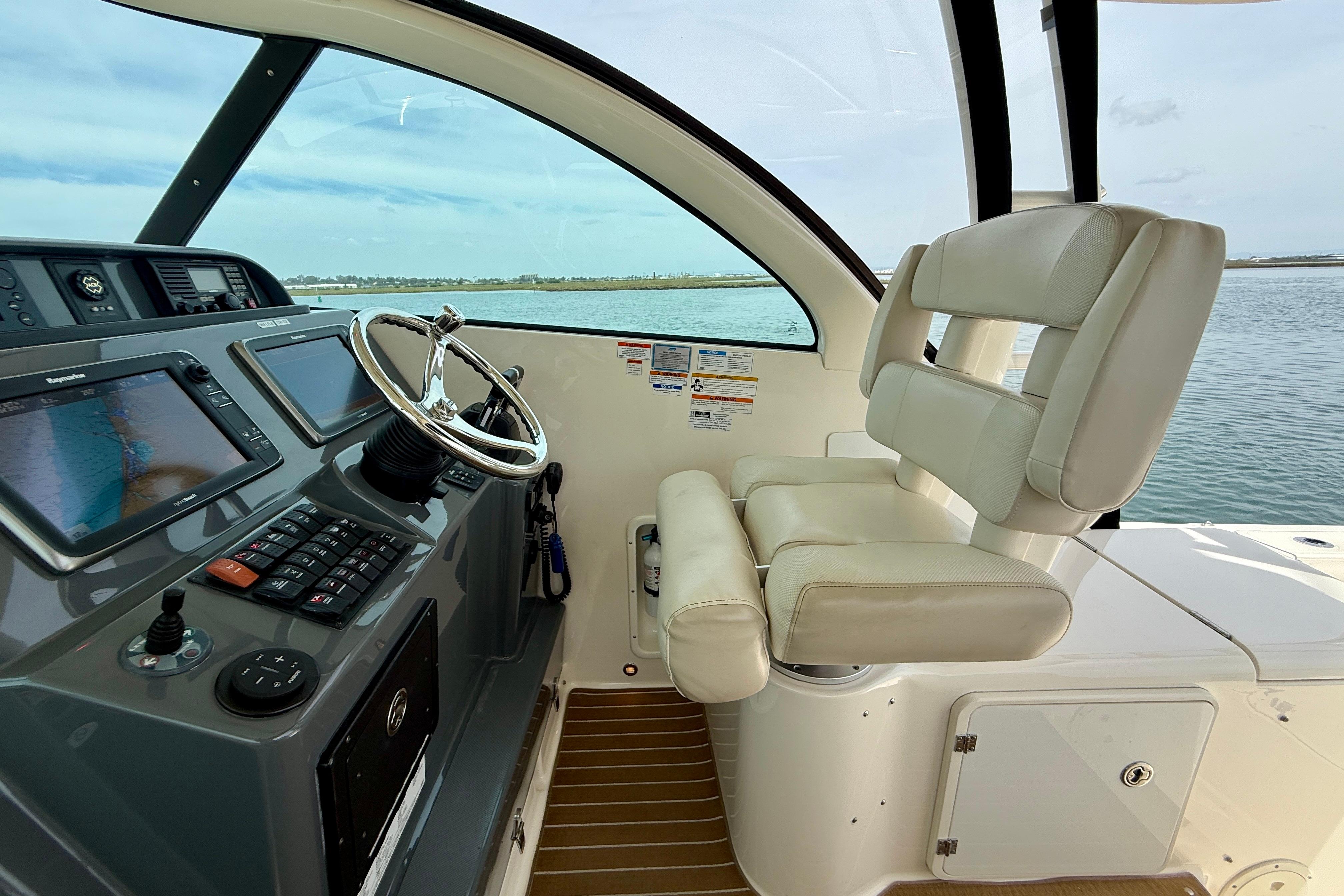 2012 Pursuit OS 345 Offshore helm with steering wheel and navigation screens.