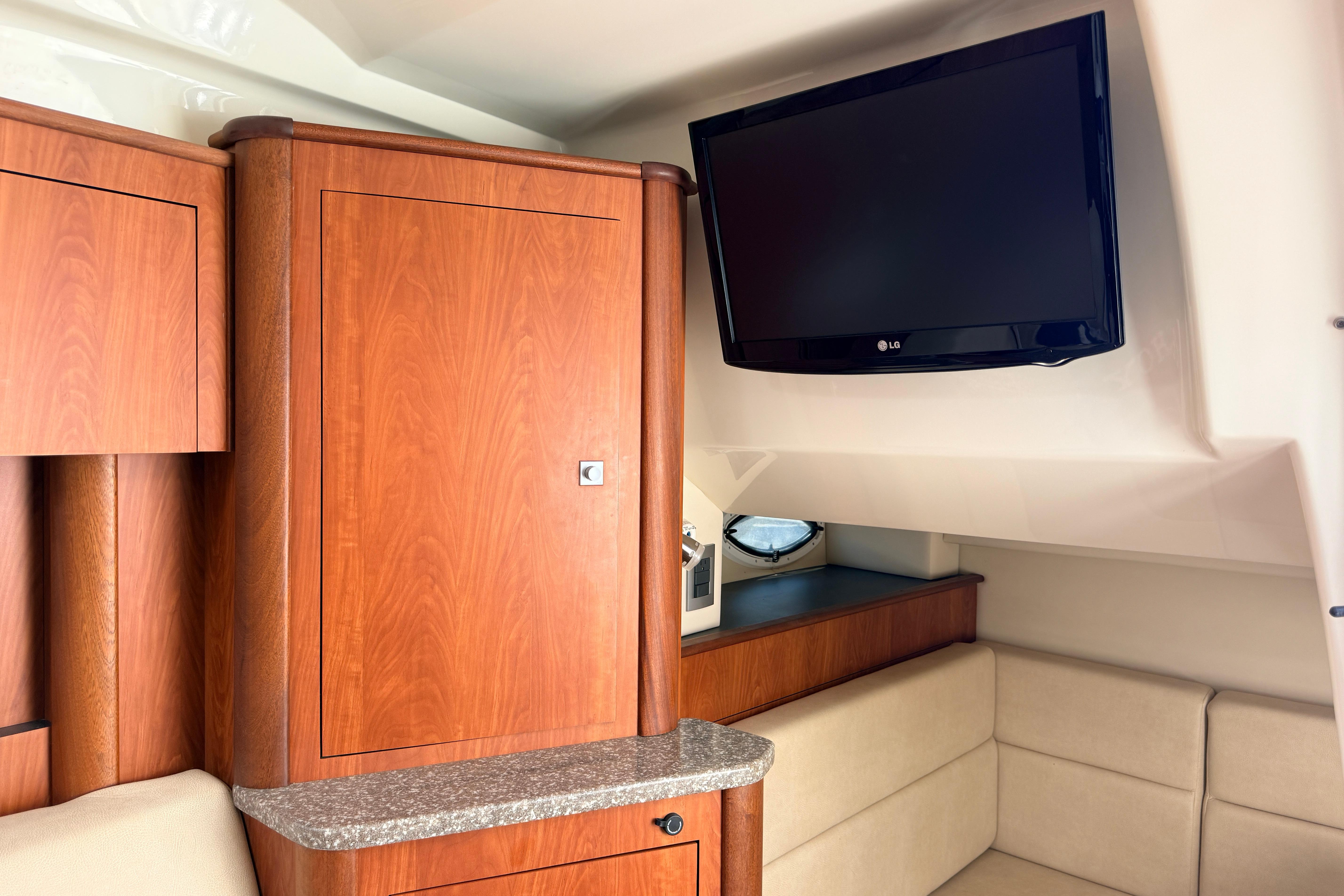 Interior of 2011 Monterey 320 Sport Yacht with wood cabinetry and mounted LG TV.